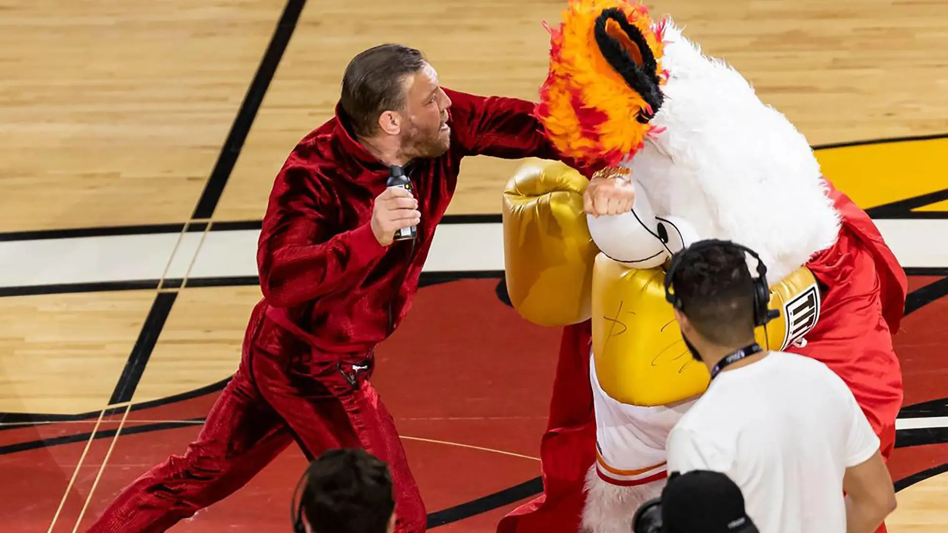June 9, 2023, Miami, Florida, USA: Mixed martial arts fighter CONOR MCGREGOR, 34, left, swings at Miami Heat mascot Burnie during a timeout period in Game 4 of the NBA, Basketball Herren, USA Finals against the Denver Nuggets at the Kaseya Center in Miami. Miami Florida - ZUMAm67_ 20230610_zaf_m67_013 Copyright: xMatiasxJ.xOcnerx