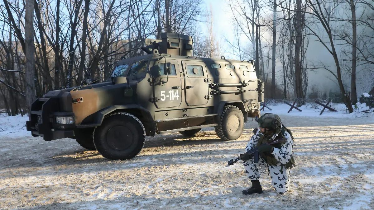 04.02.2022, Ukraine, Prypjat: Ein Soldat der Spezialeinheiten der ukrainischen Nationalgarde kniet während einer Militärübung in der verlassenen Stadt Prypjat in der Nähe des Kernkraftwerks Tschernobyl neben einem Militärfahrzeug. Foto: Mykola Tymchenko/AP/dpa +++ dpa-Bildfunk +++