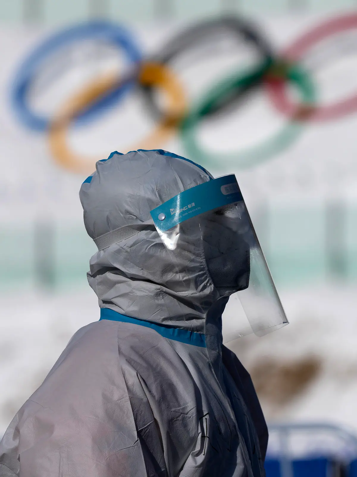 04.02.2022, China, Zhangjiakou: Biathlon, Olympia, Nationales Biathlonzentrum. Ein Arbeiter in Schutzkleidung geht bei den Olympischen Winterspielen 2022 durch das Nationale Biathlonzentrum. Foto: Frank Augstein/AP/dpa +++ dpa-Bildfunk +++