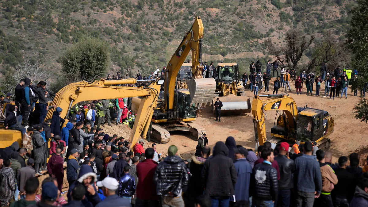 Residents watch civil defense workers and local authorities attempting to rescue a 5 year old boy who fell into a hole near the town of Bab Berred near Chefchaouen, Friday, Feb. 4, 2022 in Ighran. A third day of efforts to rescue a 5-year-old boy who fell into a well in northern Morocco was halted for a time on Friday following concerns about ground stability, fueling despair among those hoping to reach him. The boy, identified as Rayan, fell into a 32-meter (105-feet) deep well located outside his home in the northern village of Ighran in Morocco's Chefchaouen province on Tuesday evening.(AP Photo/Mosa'ab Elshamy)