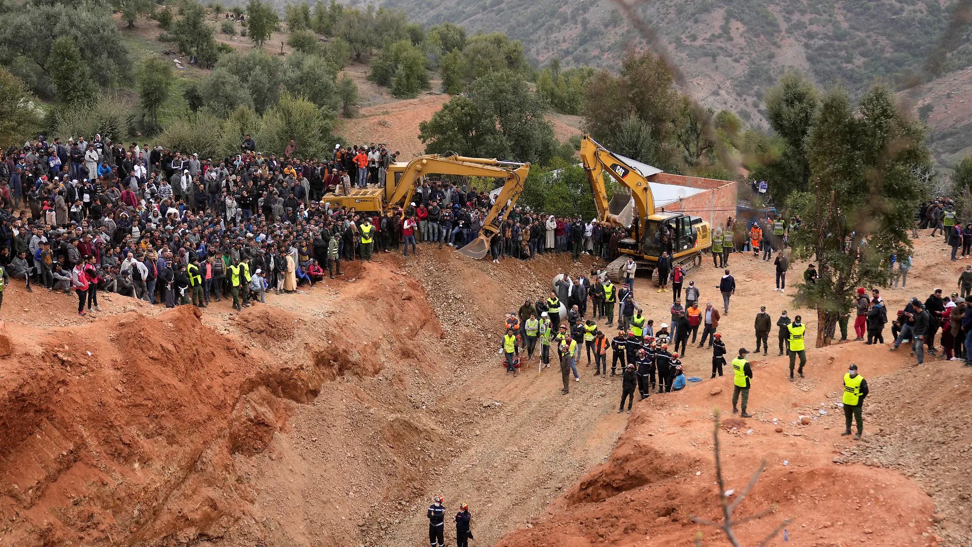 Civil defense workers and local authorities attempt to rescue a 5 year old boy who fell into a hole near the town of Bab Berred near Chefchaouen, Friday, Feb. 4, 2022 in Ighran. A third day of efforts to rescue a 5-year-old boy who fell into a well in northern Morocco was halted for a time on Friday following concerns about ground stability, fueling despair among those hoping to reach him. The boy, identified as Rayan, fell into a 32-meter (105-feet) deep well located outside his home in the northern village of Ighran in Morocco's Chefchaouen province on Tuesday evening.(AP Photo/Mosa'ab Elshamy)