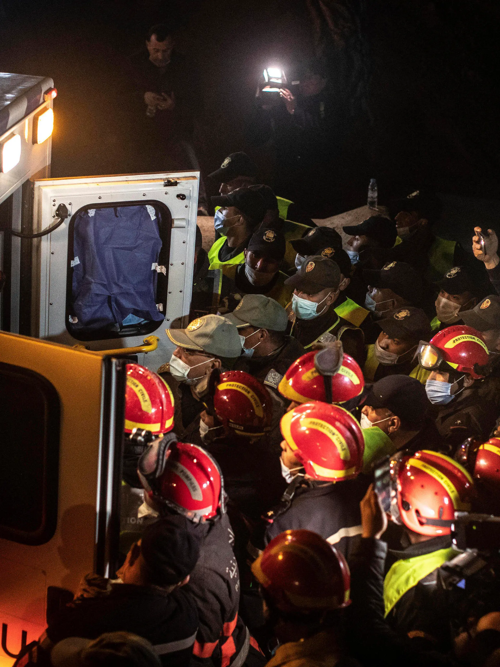Rescue workers carry the body of 5-year-old Rayan and place it in an ambulance after it was retrieved from a hole in which he was stuck for several days, in the village of Ighran in Morocco's Chefchaouen province, Saturday, Feb. 5, 2022. The boy died and was pulled out Saturday night by rescuers after a lengthy operation that captivated global attention. (AP Photo/Mosa'ab Elshamy)