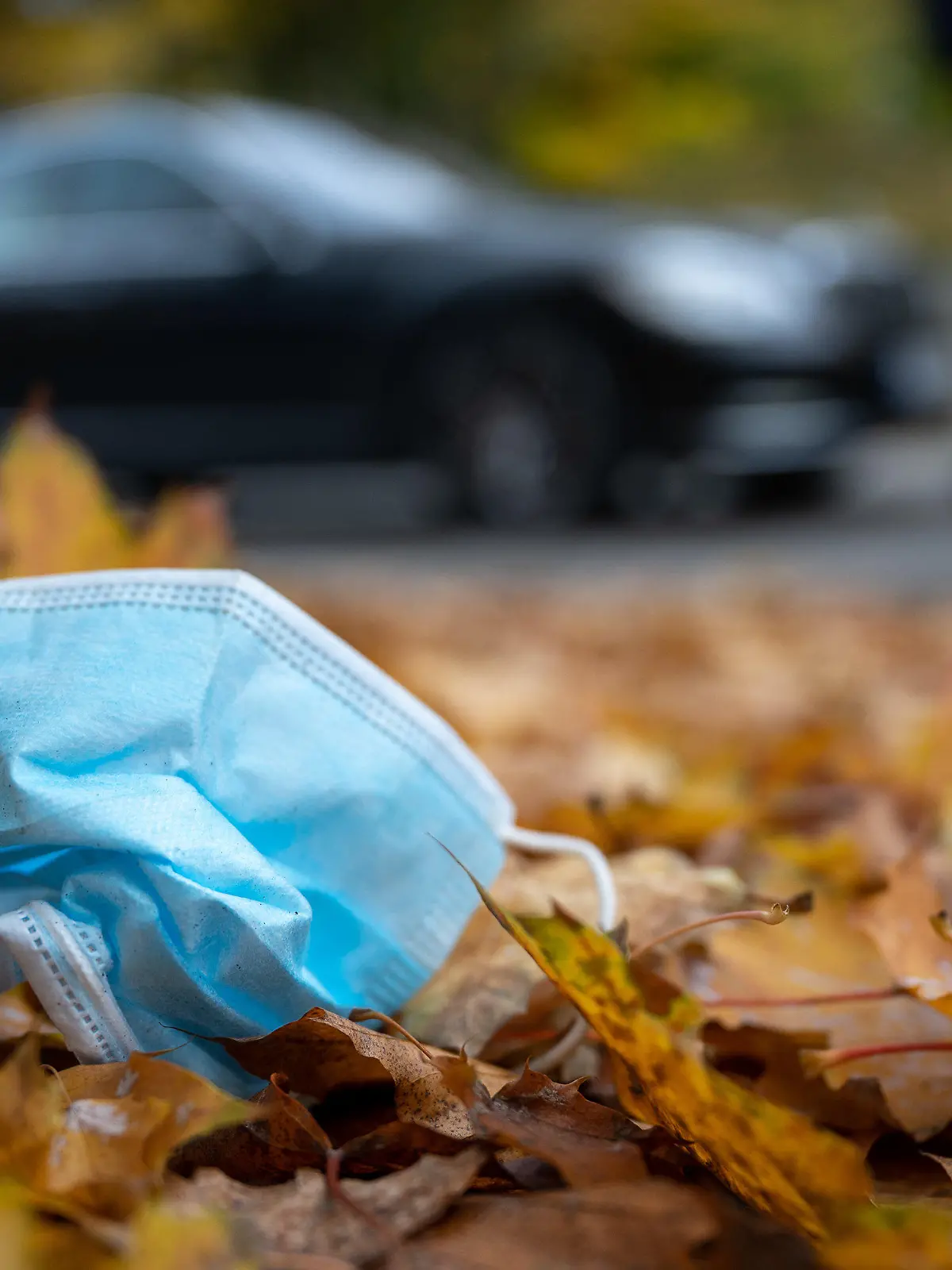 ARCHIV - 19.10.2020, Baden-Württemberg, Bad Urach: Eine Gesichtsmaske liegt am Straßennrand im Herbstlaub. (zu dpa: «Falsche Entsorgung von Masken - Corona verändert Müllaufkommen») Foto: Sebastian Gollnow/dpa +++ dpa-Bildfunk +++