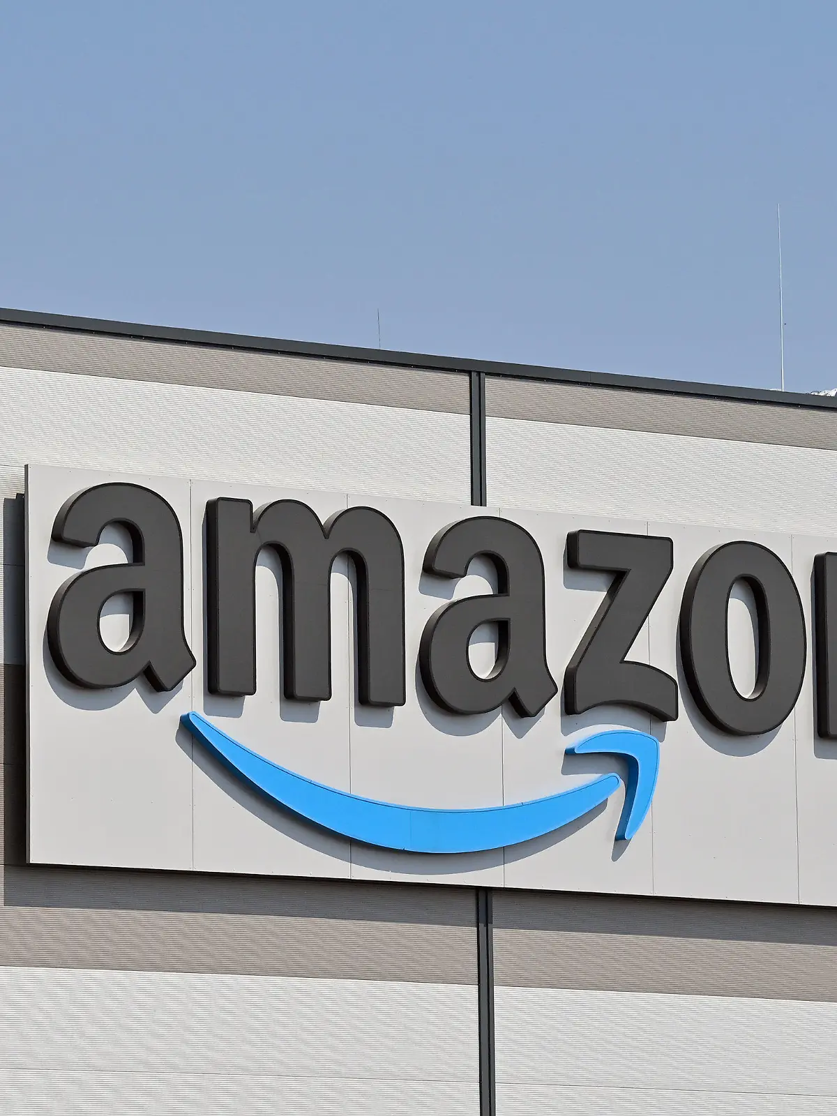 ARCHIV - 28.04.2021, Brandenburg, Kiekebusch: Das Logo von Amazon, (Amazon.com, Inc., börsennotierter US-amerikanischer Onlineversandhändler), am Versandlager in Kiekebusch, einem Ortsteil der Gemeinde Schönefeld im Landkreis Dahme-Spreewald. Amazon  gibt am 03.02.2022 Zahlen für das 4. Quartal bekannt. Foto: Patrick Pleul/dpa-Zentralbild/dpa +++ dpa-Bildfunk +++