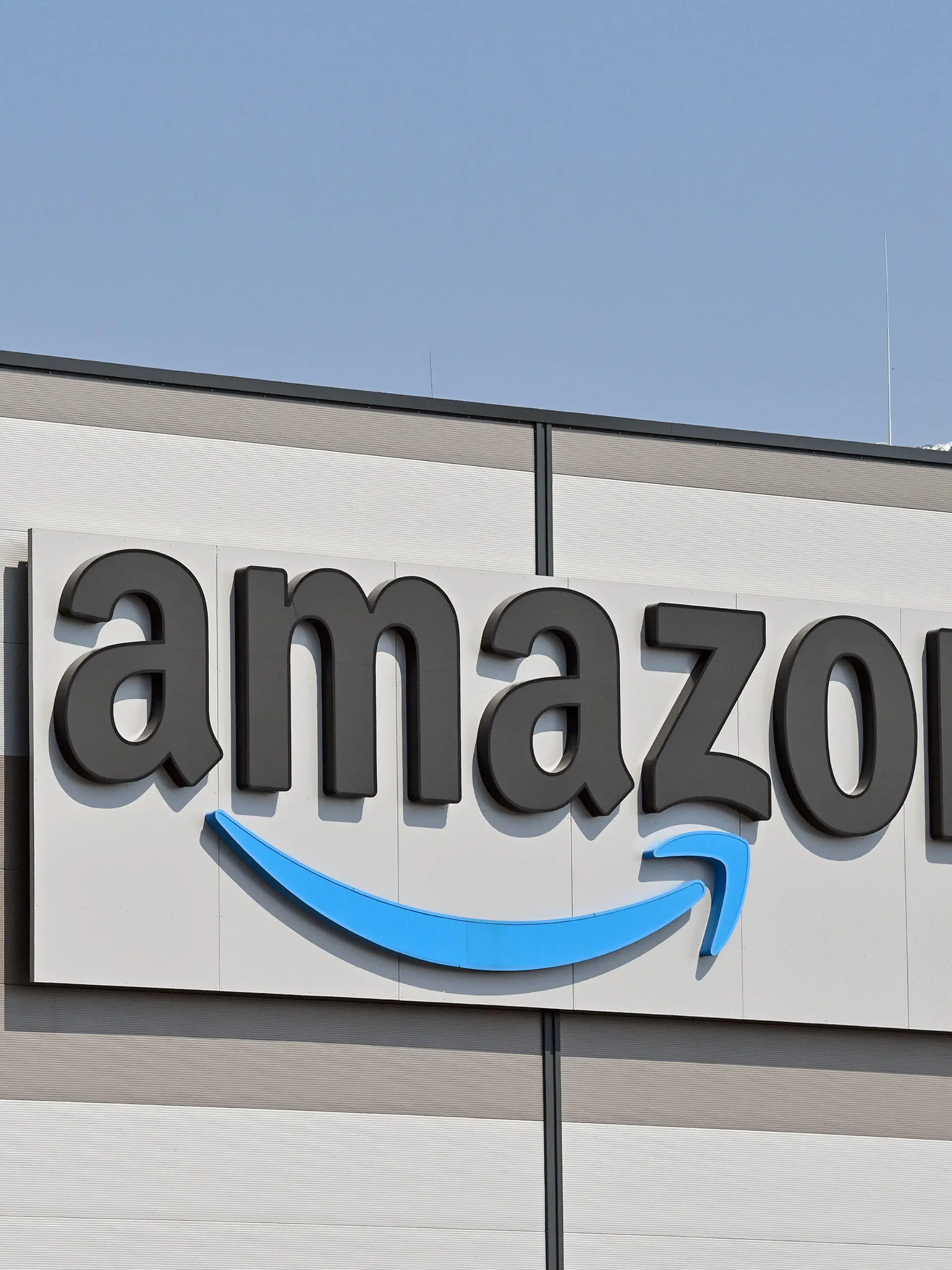 ARCHIV - 28.04.2021, Brandenburg, Kiekebusch: Das Logo von Amazon, (Amazon.com, Inc., börsennotierter US-amerikanischer Onlineversandhändler), am Versandlager in Kiekebusch, einem Ortsteil der Gemeinde Schönefeld im Landkreis Dahme-Spreewald. Amazon  gibt am 03.02.2022 Zahlen für das 4. Quartal bekannt. Foto: Patrick Pleul/dpa-Zentralbild/dpa +++ dpa-Bildfunk +++