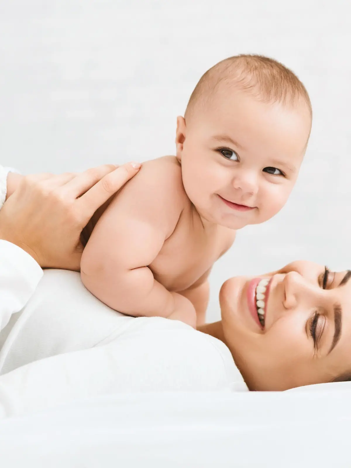 Family having fun together. Mom and baby boy in diaper playing in bedroom, panorama, copy space