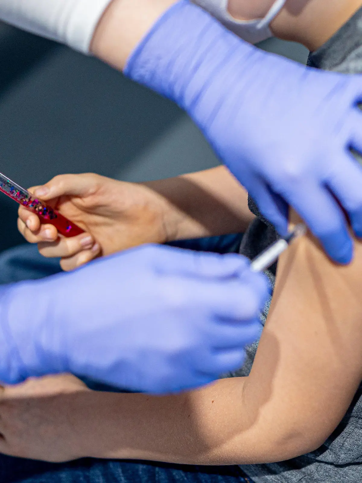 29.01.2022, Niedersachsen, Wolfsburg: Julius lässt sich im phaeno Wolfsburg gegen das Coronavirus impfen und hält dabei zur Ablenkung einen "Zauberstab" in seiner Hand (gestellte Szene). In dem Erlebnismuseum findet eine Kinder-Impfaktion zur Eindämmung des Coronavirus statt. Alle Kinder und Jugendlichen sowie ihre begleitenden Familienmitglieder sollten im Anschluss an die Impfung einen Gratiseintritt ins phaeno erhalten. Foto: Moritz Frankenberg/dpa +++ dpa-Bildfunk +++