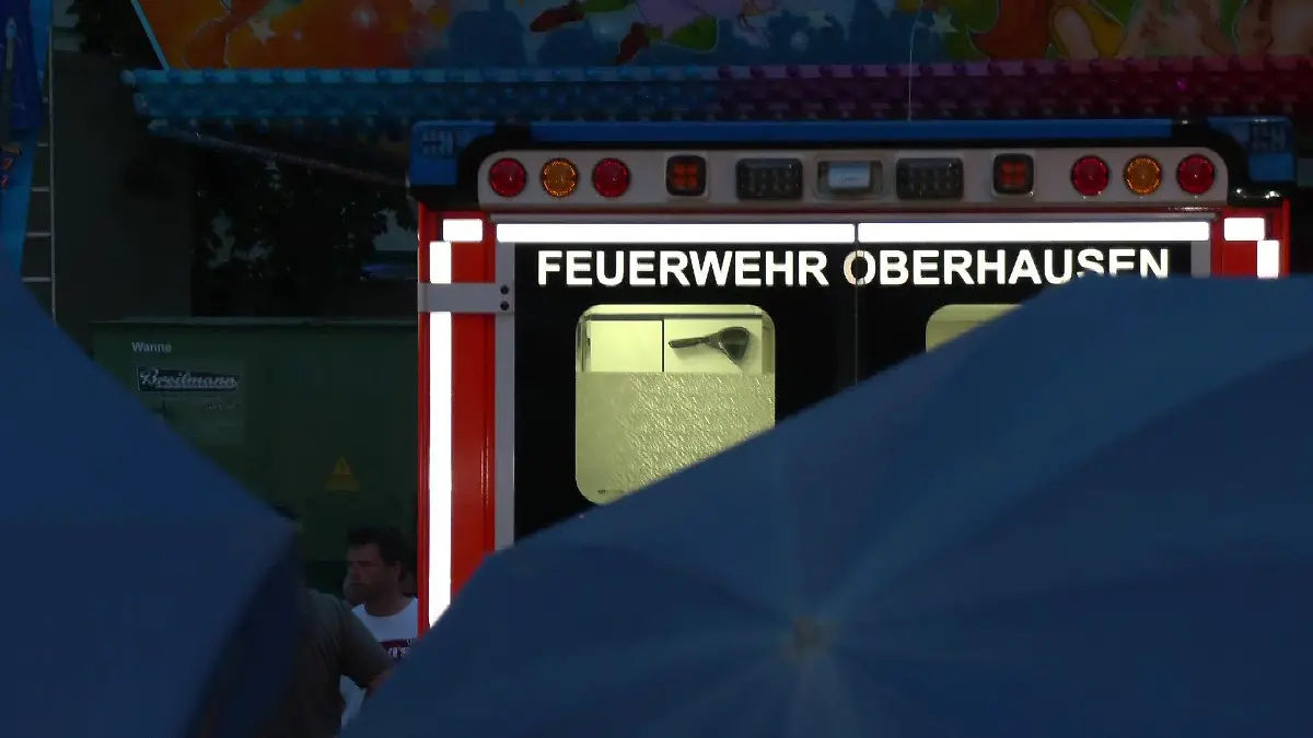 Ein Rettungswagen der Feuerwehr Oberhausen steht am Unglücksort. Auf der Fronleichnamskirmes ist am Sonntag (11. Juni 2023) der 18-jährige Mitarbeiter eines Fahrgeschäfts gestorben.