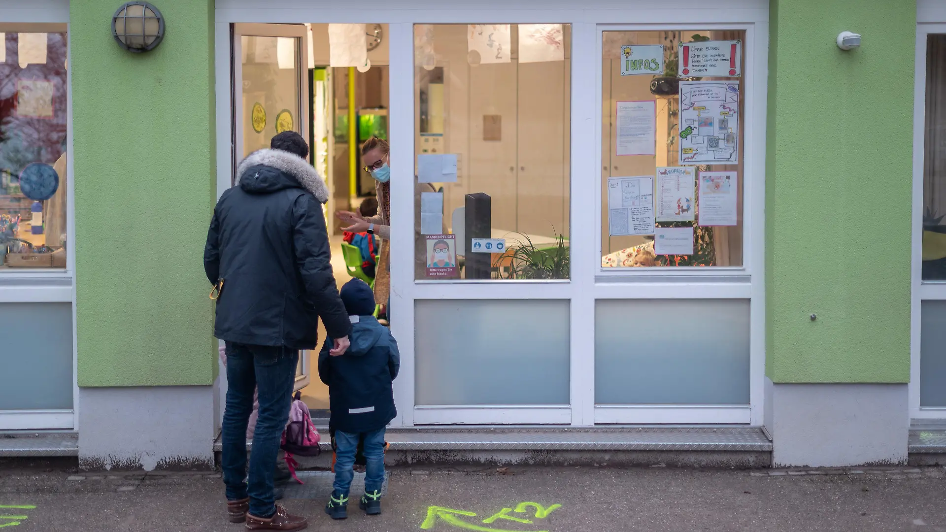 02.02.2022, Hessen, Darmstadt: Ein Vater bringt seine Kinder in eine Kita. Er muss sie vor der Tür abgeben und darf aufgrund der Maßnahmen gegen das Coronavirus nicht in die Räume gehen. Der hessische Elternbund fordert landesweit einheitliche Quarantäne-Regeln in Kitas. Foto: Sebastian Gollnow/dpa +++ dpa-Bildfunk +++