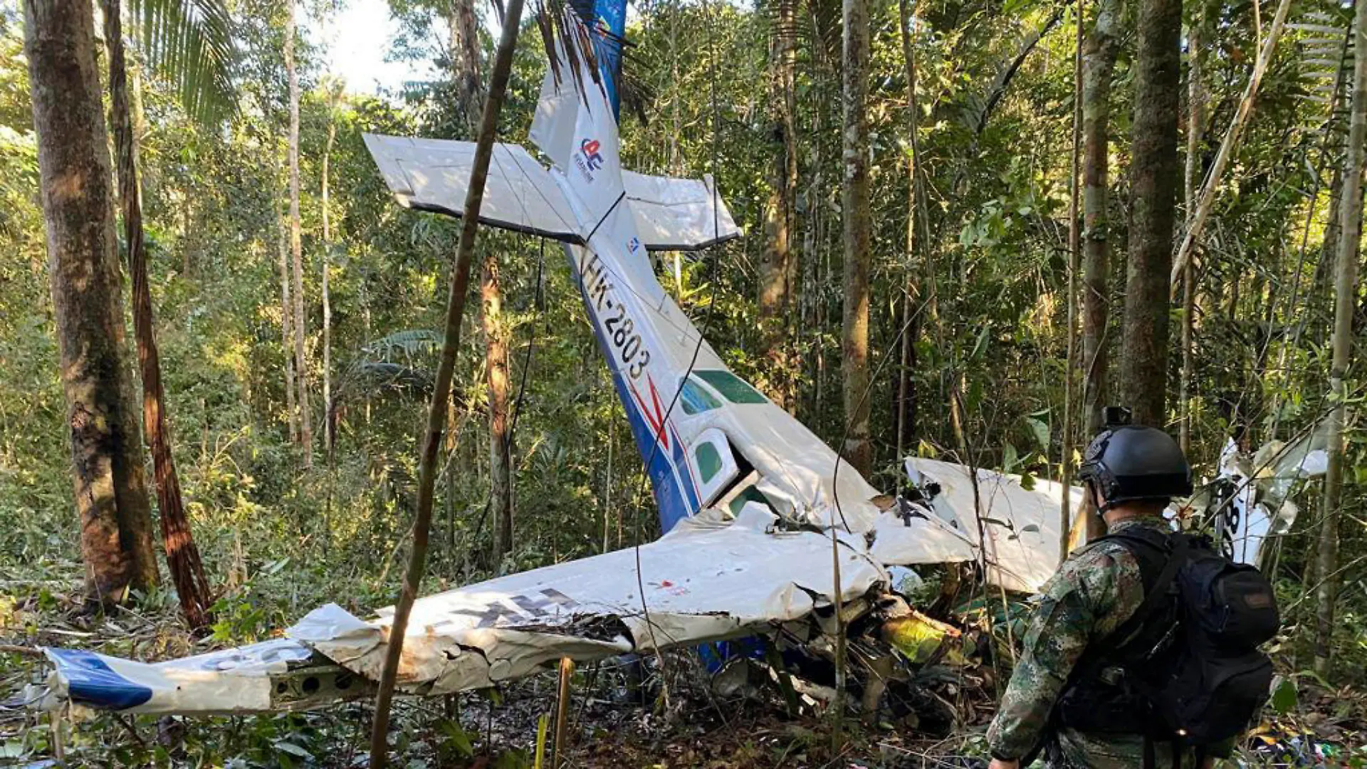 ARCHIV - 20.05.2023, Kolumbien, Caqueta: HANDOUT - Auf diesem von der Pressestelle der kolumbianischen Streitkräfte veröffentlichten Bild steht ein Soldat vor dem Wrack einer Cessna C206, die am 18. Mai 2023 im Dschungel von Solano im kolumbianischen Bundesstaat Caqueta abgestürzt ist. Über einen Monat nach dem Absturz eines Kleinflugzeugs im kolumbianischen Regenwald sind alle vier vermissten Kinder lebend gefunden worden. Das teilte der kolumbianische Präsident Petro am Freitag auf Twitter mit. Die Geschwister - 13, 9, 4 und 1 Jahr alt - waren am 1. Mai verunglückt. (zu dpa «Kinder nach Flugzeugabsturz im Regenwald lebend gefunden») Foto: -/Pressebüro der kolumbianischen Streitkräfte via AP/dpa - ACHTUNG: Nur zur redaktionellen Verwendung und nur mit vollständiger Nennung des vorstehenden Credits +++ dpa-Bildfunk +++