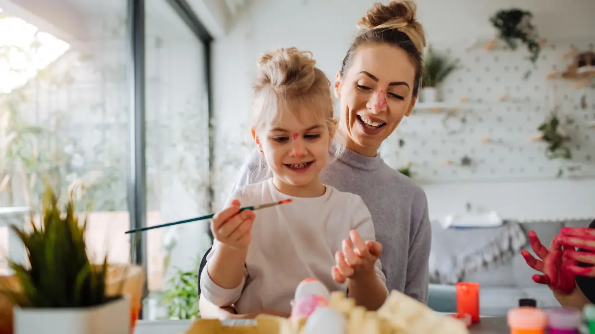 Mother and daughter coloring Easter eggs