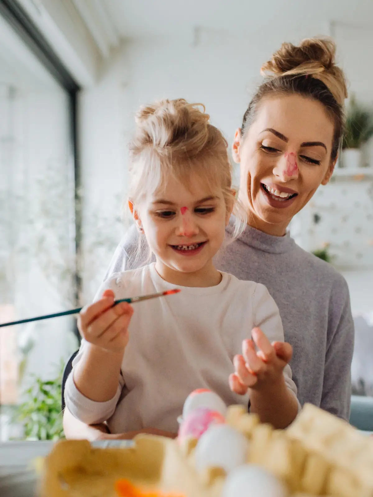 Mother and daughter coloring Easter eggs