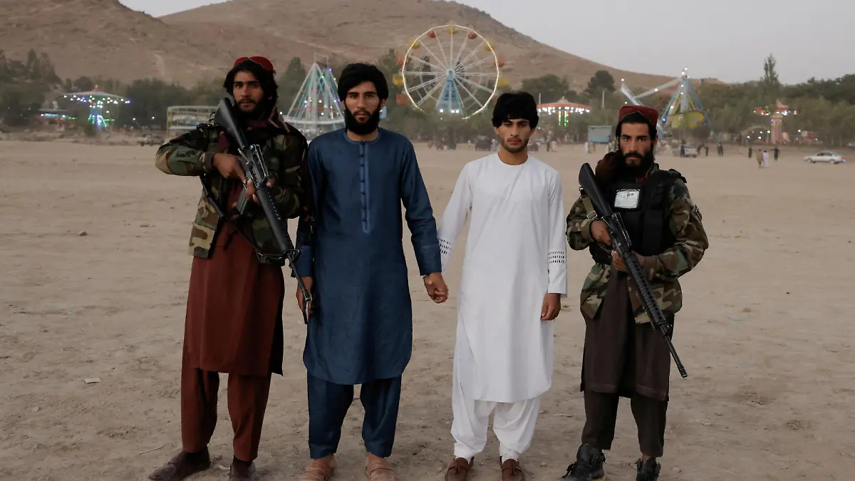 FILE PHOTO: Park visitors pose with Taliban fighters from Wardak province during their first visit to Kabul as they take a day off to visit the amusement park at Kabul's Qargha reservoir, at the outskirts of Kabul, Afghanistan October 8, 2021. Picture taken October 8, 2021. REUTERS/Jorge Silva/File Photo