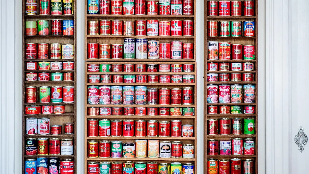 01.02.2022, Niedersachsen, Oldenburg: Zahlreiche Tomatenmarkdosen aus verschiedenen Ländern stehen in einem Regal im Esszimmer von Sammlerin Tuchenhagen. Die Oldenburgerin hat seit 1983 rund 490 verschiedene Tomatenmarkdosen aus aller Wellt gesammelt. Foto: Hauke-Christian Dittrich/dpa +++ dpa-Bildfunk +++
