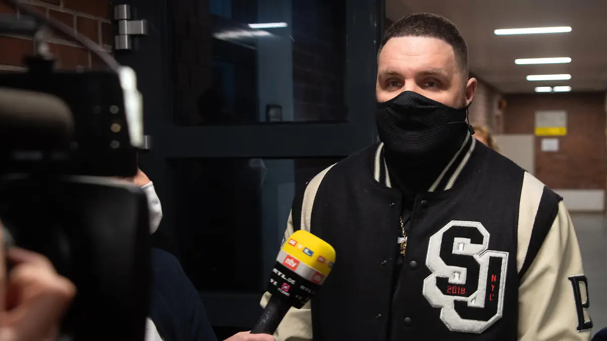 15.01.2021, Berlin: Rapper Fler, bürgerlich Patrick Losensky, gibt auf dem Weg zum Gerichtssaal einem Fernsehsender ein Interview. Dem 38-Jährigen werden Beleidigung, Sachbeschädigung, versuchte Nötigung und Fahren ohne Fahrerlaubnis vorgeworfen. Immer wieder soll der Musiker verschiedene Menschen wüst verunglimpft und beleidigt haben. Das Verfahren hatte bereits im November 2020 begonnen, musste dann aber wegen Erkrankung des Angeklagten ausgesetzt werden. Foto: Paul Zinken/dpa-Zentralbild/dpa +++ dpa-Bildfunk +++