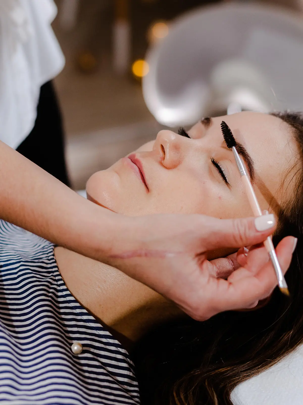 Young woman on eyebrow correction in cosmetology clinic