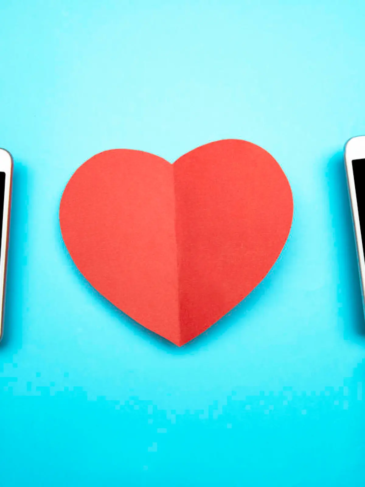 Two hands holding smart phones and a red heart shape on blue background. Representing online dating mobile applications.