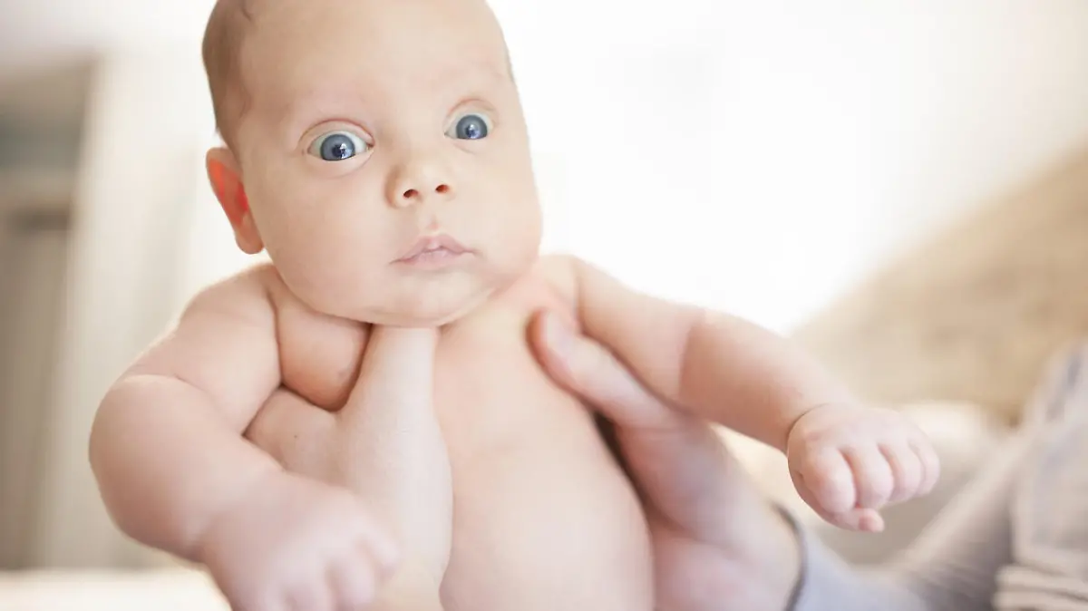 Shot of a baby boy looking shocked while his father holds him