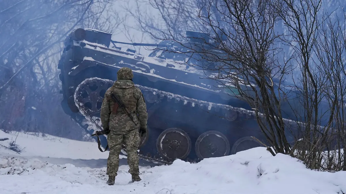 An Ukrainian serviceman as an armored personnel carrier maneuvers near front line position in the Luhansk area, eastern Ukraine, Friday, Jan. 28, 2022. High-stakes diplomacy continued on Friday in a bid to avert a war in Eastern Europe, the urgent efforts coming as 100,000 Russian troops are massed near Ukraine's border and the Biden administration worries that Russian President Vladimir Putin will mount some sort of invasion within weeks. (AP Photo/Vadim Ghirda)