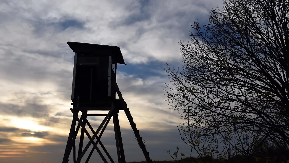 Ein Jagdhochsitz steht im Gegenlicht der untergehenden Sonn im Braunkohle-Tagebau Garzweiler bei Grevenbroich (Nordrhein-Westfalen) (Foto vom 03.12.2015). Foto: Horst Ossinger/dpa | Verwendung weltweit