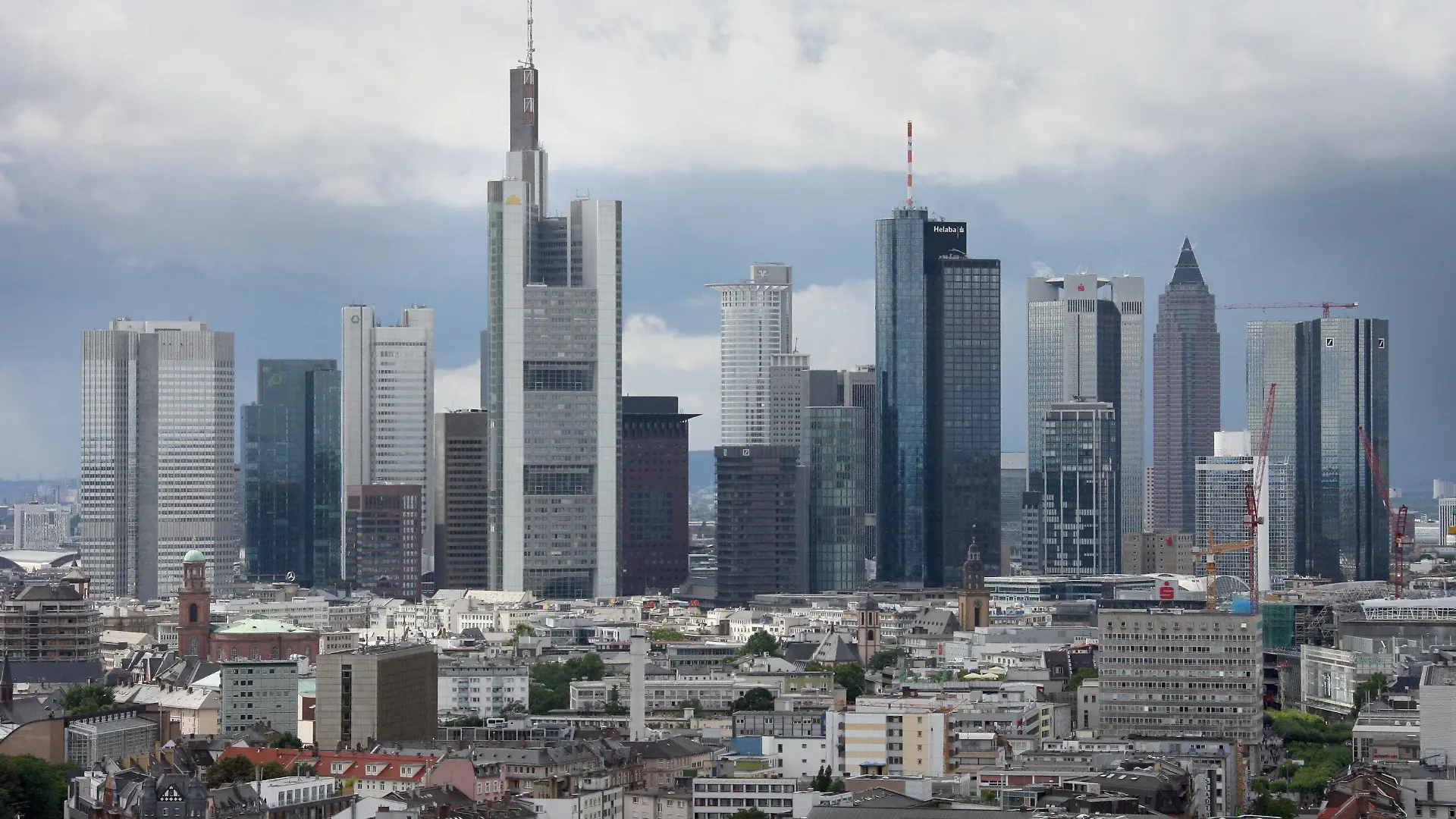 ARCHIV - Vor einer Kulisse aus dunklen Wolken erheben sich am 08.08.2008 die Hochhäuser der Banken in Frankfurt am Main über die Dächer der Mainmetropole. Die Bundesregierung hat am Montag (20.10.2008) zu Beginn der neuen Börsenwoche strenge Auflagen für Leistungen aus dem milliardenschweren Rettungspaket für die Finanzbranche beschlossen. In einer Rechtsverordnung legte das Kabinett fest, Managergehälter in notleidenden Banken generell auf maximal 500 000 Euro pro Jahr zu begrenzen. Ausnahmen sind möglich. Foto: Boris Roessler dpa/lhe +++(c) dpa - Bildfunk+++