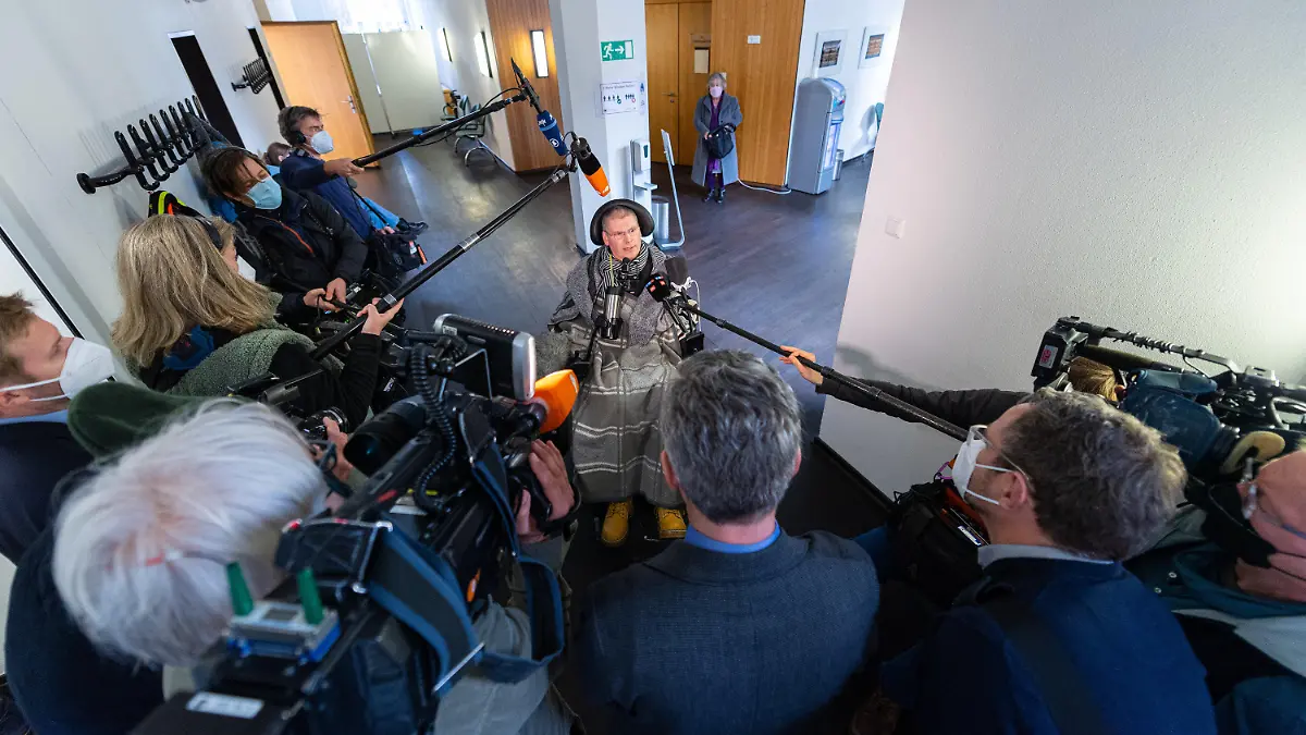 02.02.2022, Nordrhein-Westfalen, Münster: Vor dem Termin beim Oberverwaltungsgericht des Landes Nordrhein-Westfalen sitzt der Kläger Harald Mayer, der den anwesenden Medienvertretern ein Interview gibt, in seinem Rollstuhl. Die zwei Kläger und eine Klägerin aus Rheinland-Pfalz, Niedersachsen und Baden-Württemberg leiden an verschiedenen schwerwiegenden Erkrankungen (u. a. Multiple Sklerose, Krebs). Sie begehren den Zugang zum Betäubungsmittel Natriumpentobarbital zum Zweck der Selbsttötung. Das Bundesinstitut für Arzneimittel und Medizinprodukte (BfArM) in Bonn hatte die Anträge auf Erteilung einer Erlaubnis zum Erwerb des Betäubungsmittels Natriumpentobarbital abgelehnt. Das OVG will nach der mündlichen Verhandlung ein Urteil verkünden (Az.: 9 A 146/21, 9 A 147/21 und 9 A 148/21). Foto: Guido Kirchner/dpa +++ dpa-Bildfunk +++