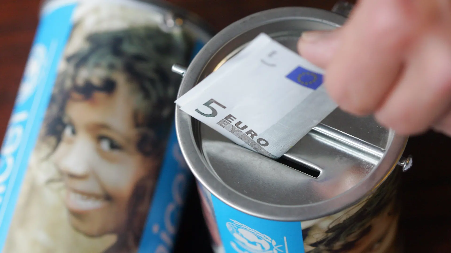 ARCHIV - Ein Fünf-Euro-Schein wird in Witten in eine Spendendose des Kinderhilfswerks UNICEF gesteckt (Archivfoto -Illustration vom 05.02.2008). In der Vorweihnachtszeit flattern oft gleich mehrere Spendenbriefe am Tag ins Haus. Alle möglichen Organisationen bitten da um Geld - für Hunger leidende Kinder, verwahrloste Tiere +++(c) dpa - Bildfunk+++oder Opfer von Naturkatastrophen. Foto: Bernd Thissen dpa/lrs (zu lrs-Korr "Vor Weihnachten hat Spenden-Werbung Hochkonjunktur" vom 18.11.2009) +++(c) dpa - Bildfunk+++