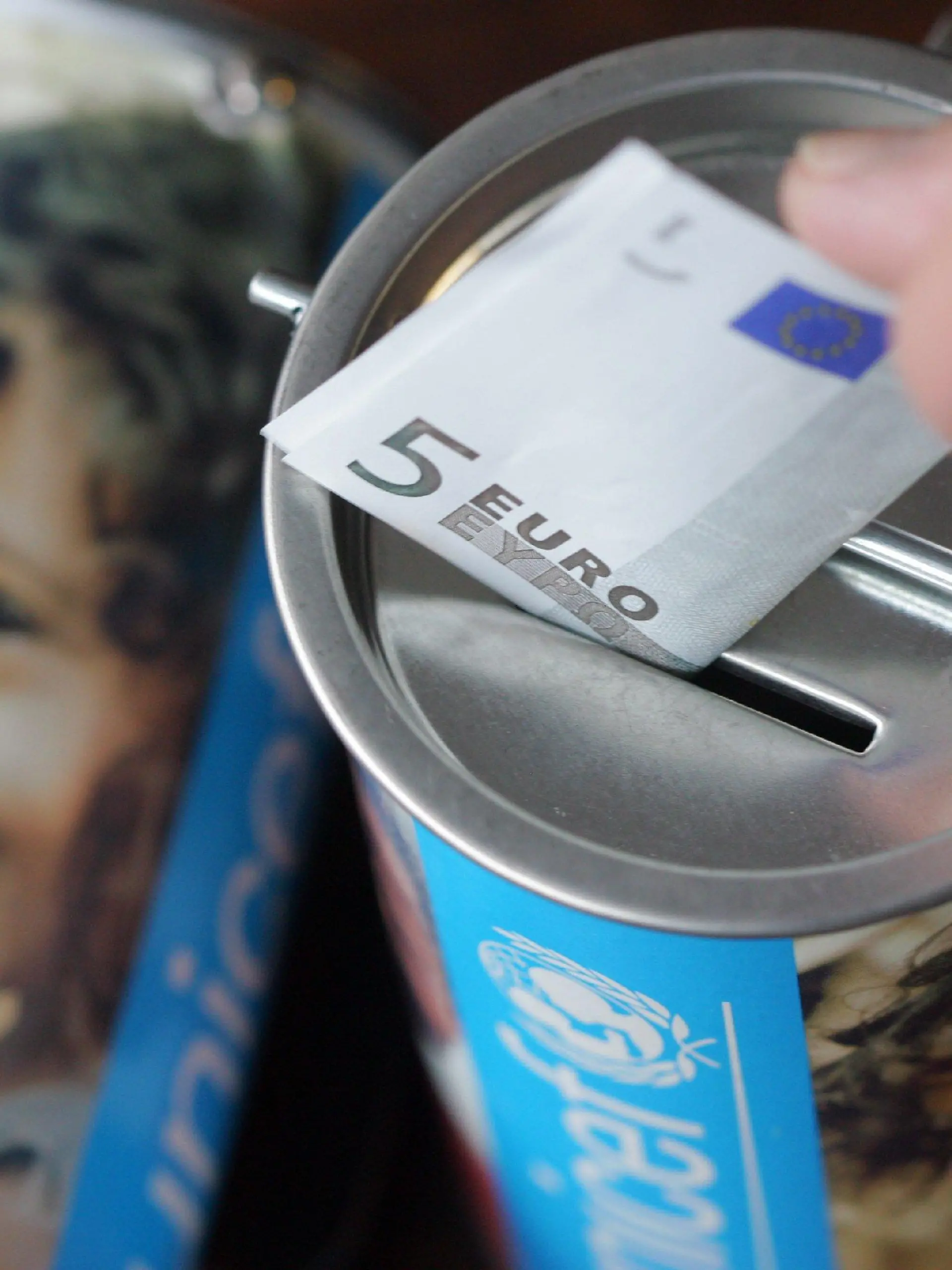 ARCHIV - Ein Fünf-Euro-Schein wird in Witten in eine Spendendose des Kinderhilfswerks UNICEF gesteckt (Archivfoto -Illustration vom 05.02.2008). In der Vorweihnachtszeit flattern oft gleich mehrere Spendenbriefe am Tag ins Haus. Alle möglichen Organisationen  bitten da um Geld - für Hunger leidende Kinder, verwahrloste Tiere +++(c) dpa - Bildfunk+++oder Opfer von Naturkatastrophen. Foto: Bernd Thissen dpa/lrs (zu lrs-Korr "Vor Weihnachten hat Spenden-Werbung Hochkonjunktur" vom 18.11.2009)  +++(c) dpa - Bildfunk+++