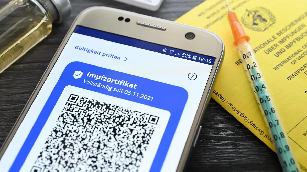 Digitales Impfzertifikat auf Smartphone, Impfausweis, Impfspritze und Schnelltest, Symbolfoto digitaler Impfnachweis und 2G-Regel *** Digital vaccination certificate on smartphone, vaccination card, vaccination syringe and rapid test, symbol photo digital vaccination certificate and 2G rule. 
