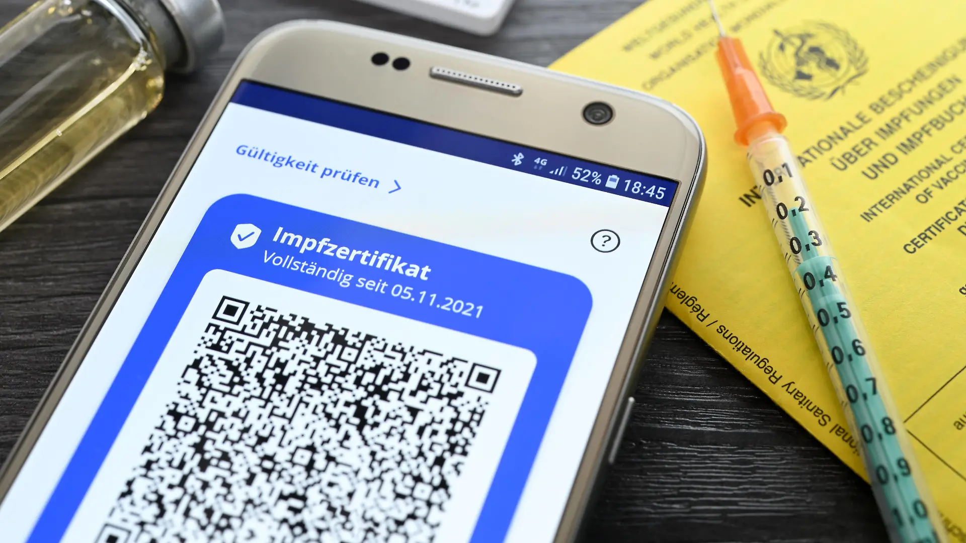 Digitales Impfzertifikat auf Smartphone, Impfausweis, Impfspritze und Schnelltest, Symbolfoto digitaler Impfnachweis und 2G-Regel *** Digital vaccination certificate on smartphone, vaccination card, vaccination syringe and rapid test, symbol photo digital vaccination certificate and 2G rule.