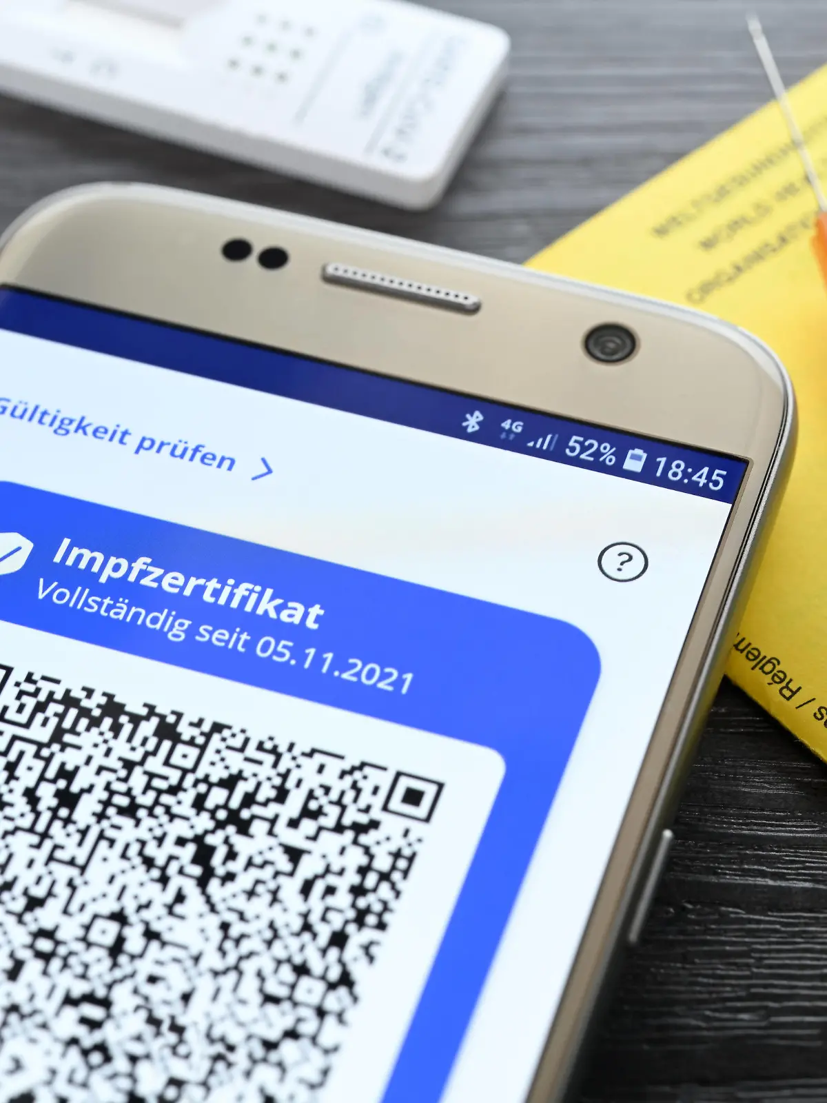 Digitales Impfzertifikat auf Smartphone, Impfausweis, Impfspritze und Schnelltest, Symbolfoto digitaler Impfnachweis und 2G-Regel *** Digital vaccination certificate on smartphone, vaccination card, vaccination syringe and rapid test, symbol photo digital vaccination certificate and 2G rule. 