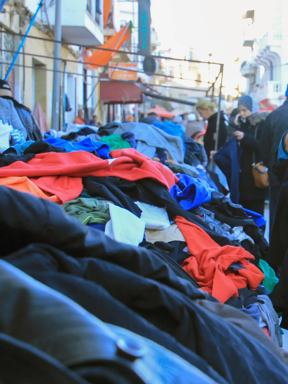Kunden schauen sich gebrauchte Kleidungsstücke auf einem zentralen Markt in Tunesiens Hauptstadt an. (zu dpa: «Minderwertige Altkleider: Afrika wird zur «Müllkippe des Westens»»)