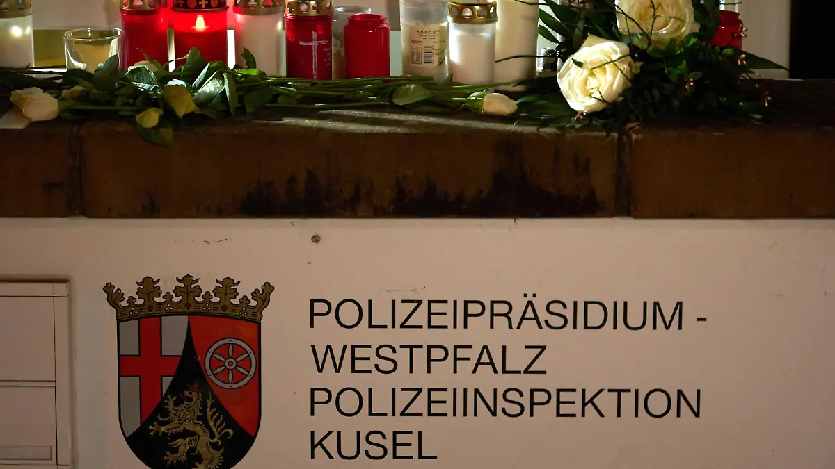 31.01.2022, Saarland, Kusel: Kerzen und Blumen liegen vor dem Gebäude des Polizeipräsidiums Westpfalz und der Polizeiinspektion Kusel. Am Morgen waren eine Polizistin und ein Polizist bei einer Verkehrskontrolle erschossen worden. Foto: Thomas Frey/dpa +++ dpa-Bildfunk +++
