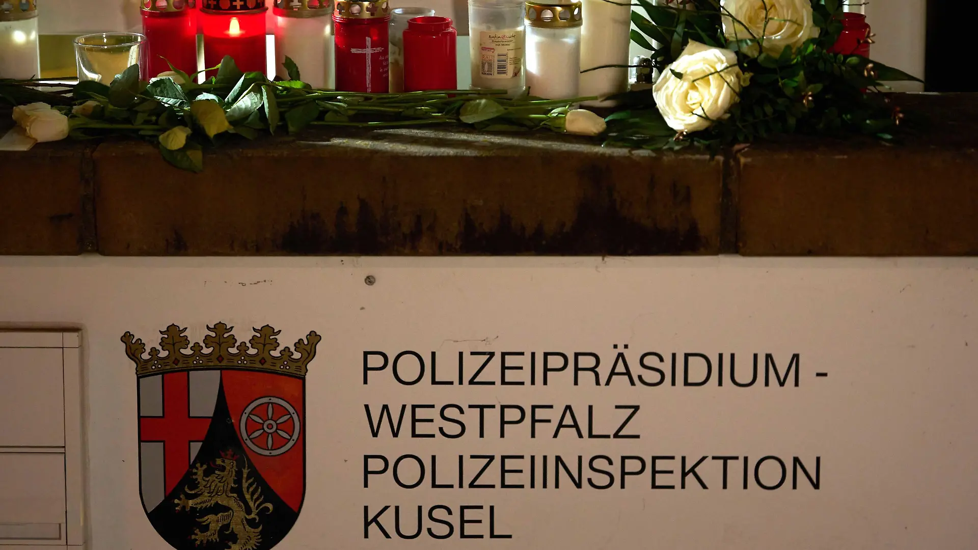 31.01.2022, Saarland, Kusel: Kerzen und Blumen liegen vor dem Gebäude des Polizeipräsidiums Westpfalz und der Polizeiinspektion Kusel. Am Morgen waren eine Polizistin und ein Polizist bei einer Verkehrskontrolle erschossen worden. Foto: Thomas Frey/dpa +++ dpa-Bildfunk +++