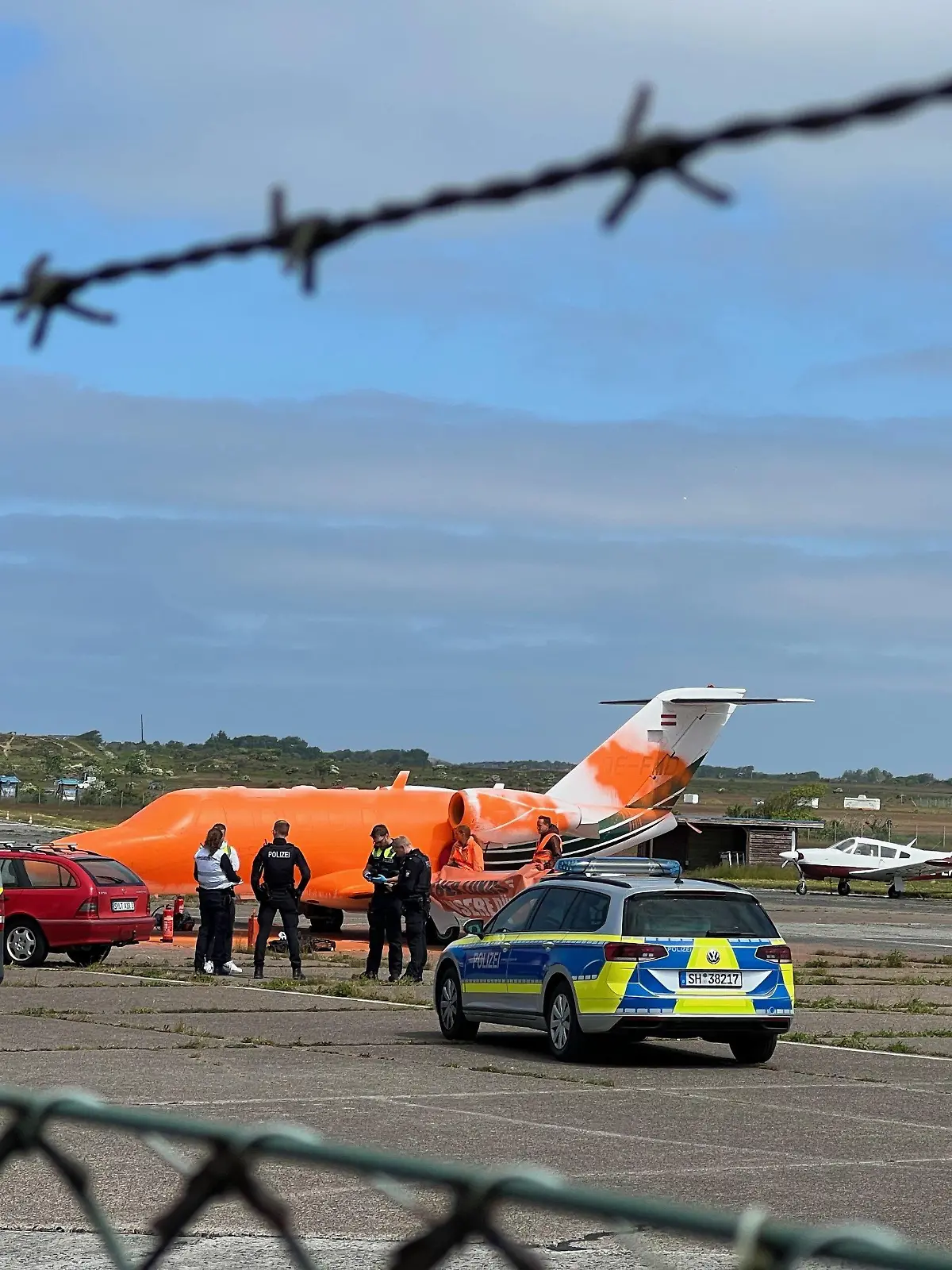 06.06.2023, Sylt: Ein von Klimaschutz-Demonstranten der Initiative Letzte Generation mit oranger Farbe besprühter Jet steht auf einem Rollfeld. (zu dpa: «Klima-Demonstranten besprühen Privatjet auf Sylt mit Farbe») Foto: Julius Schreiner/TNN/dpa +++ dpa-Bildfunk +++
