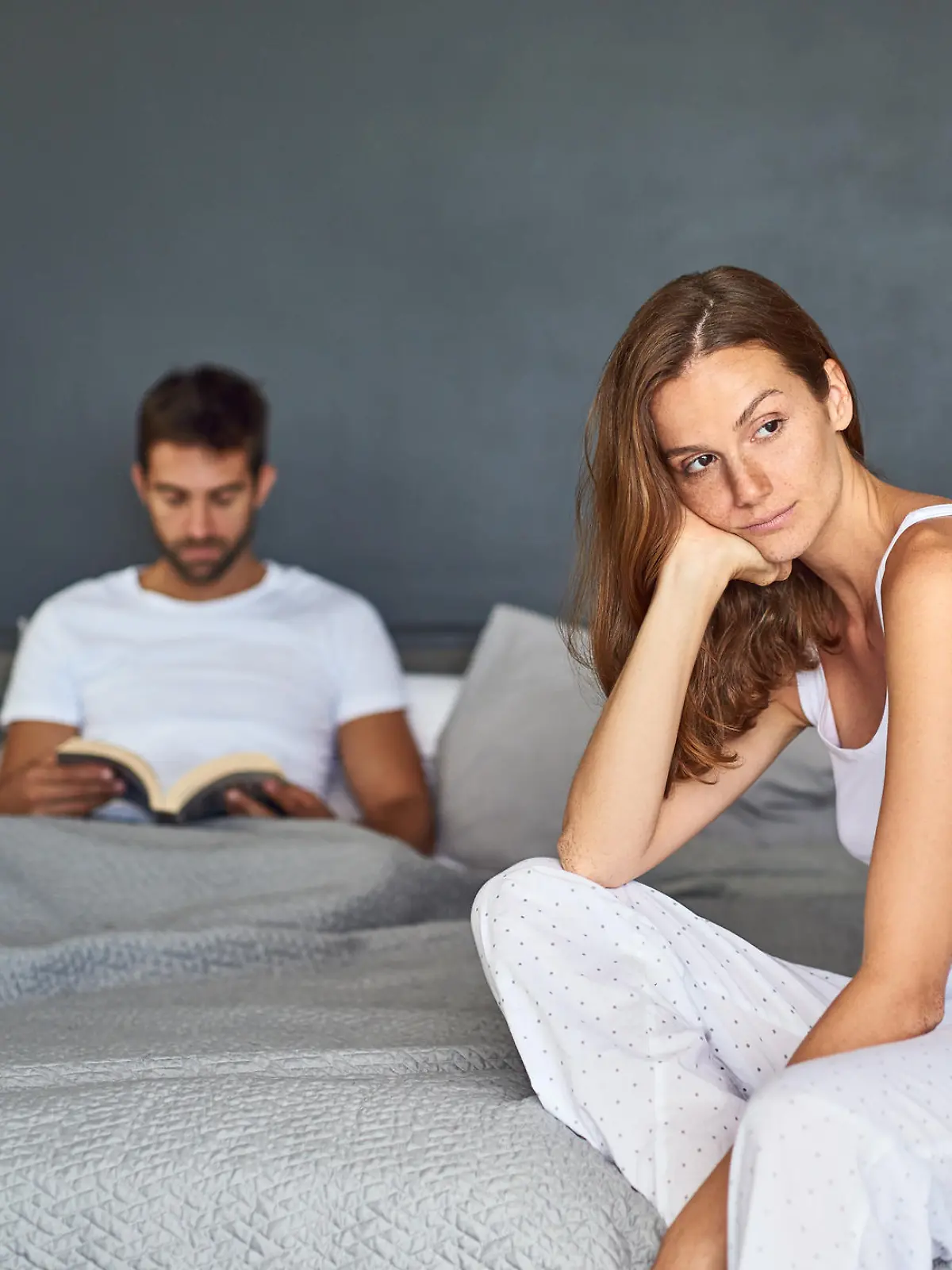 Shot of a young couple having marital problems in the bedroom at home