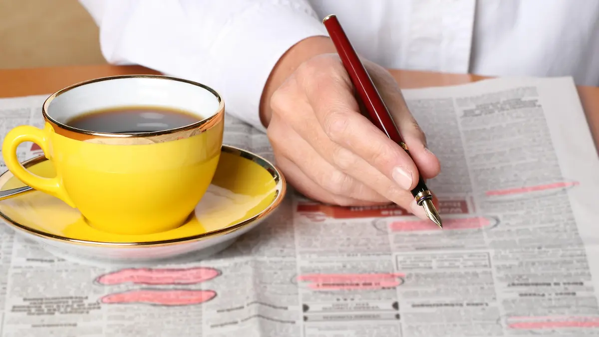 person searching for ads and job in the newspaper