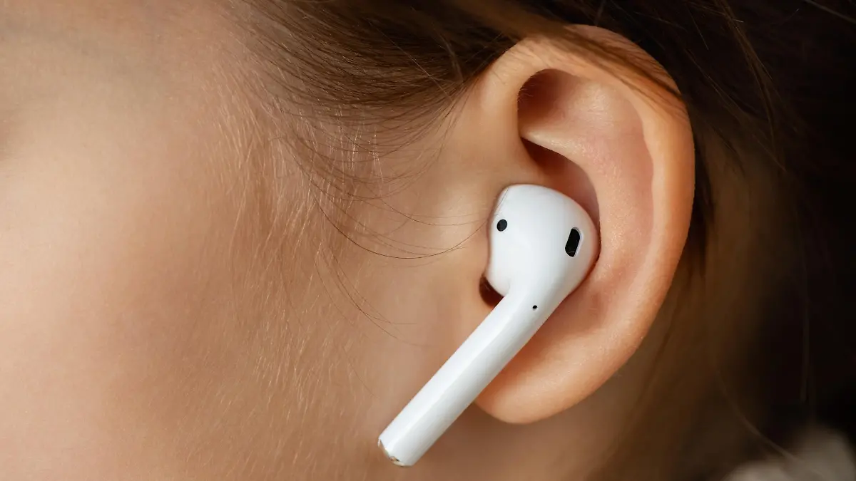 Wireless earphone in the girl's ear.