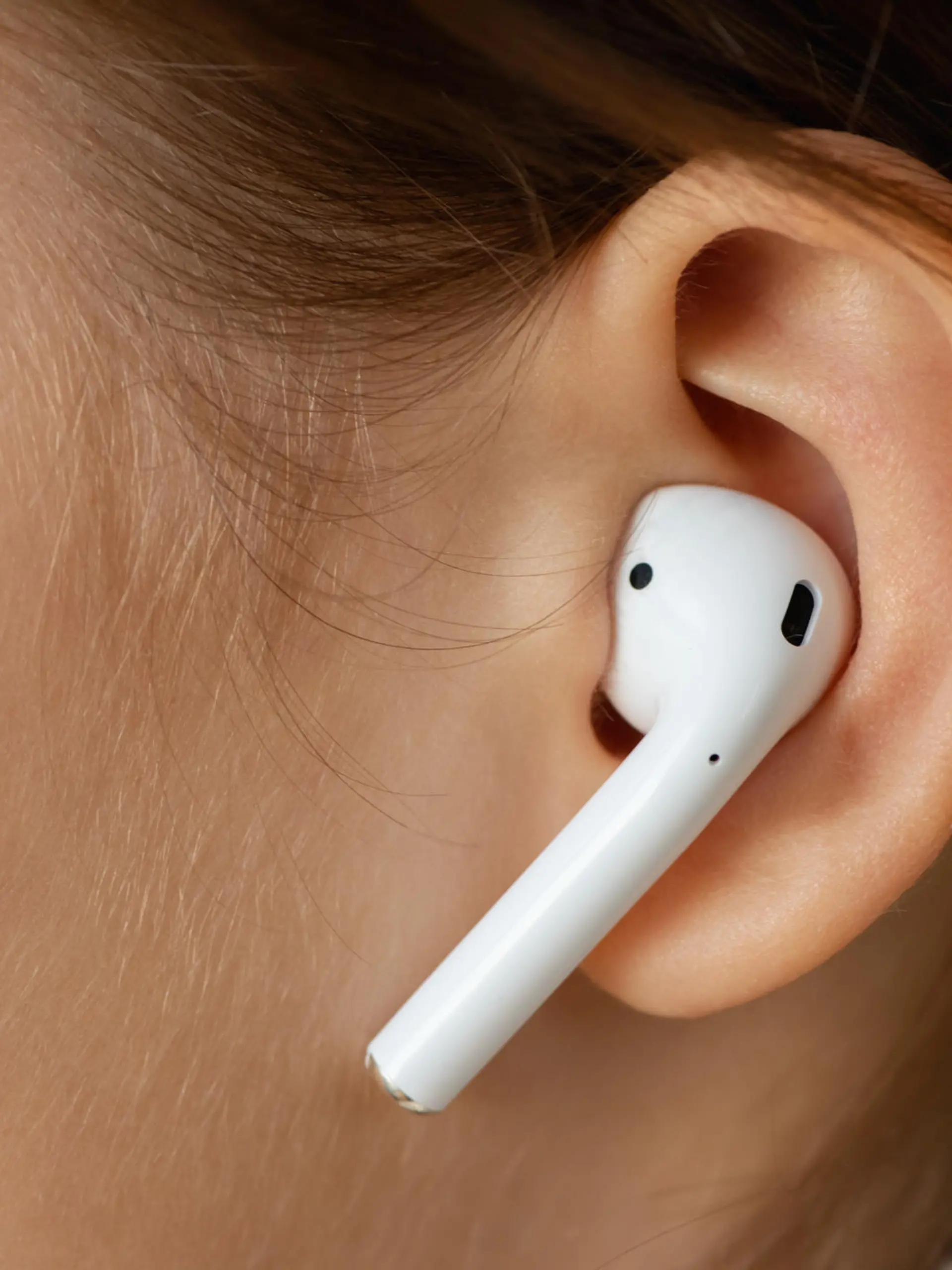 Wireless earphone in the girl's ear.
