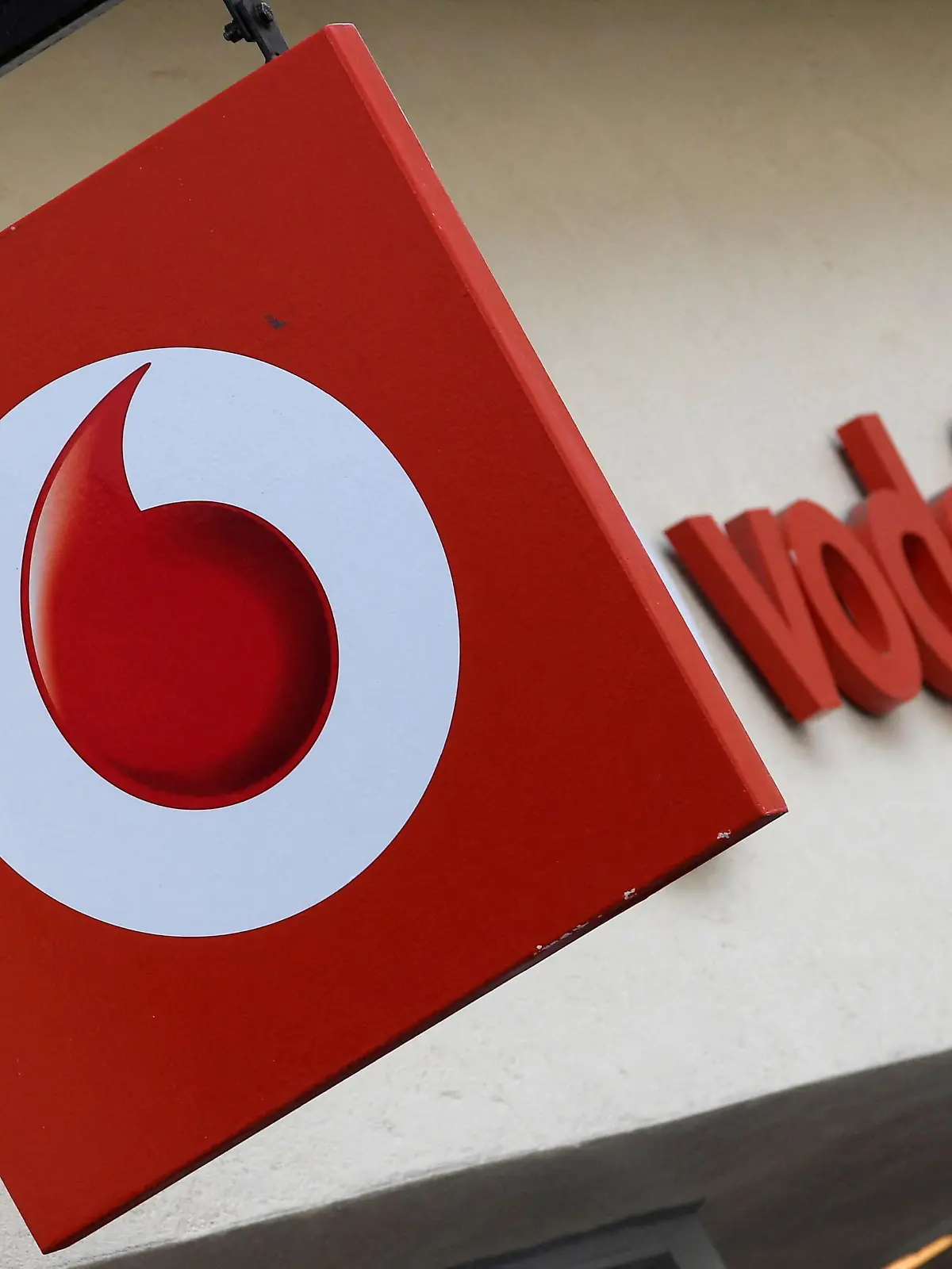 FILE PHOTO: Branding hangs outside a Vodafone shop in Oxford, Britain, May 16, 2017. REUTERS/Toby Melville/File Photo