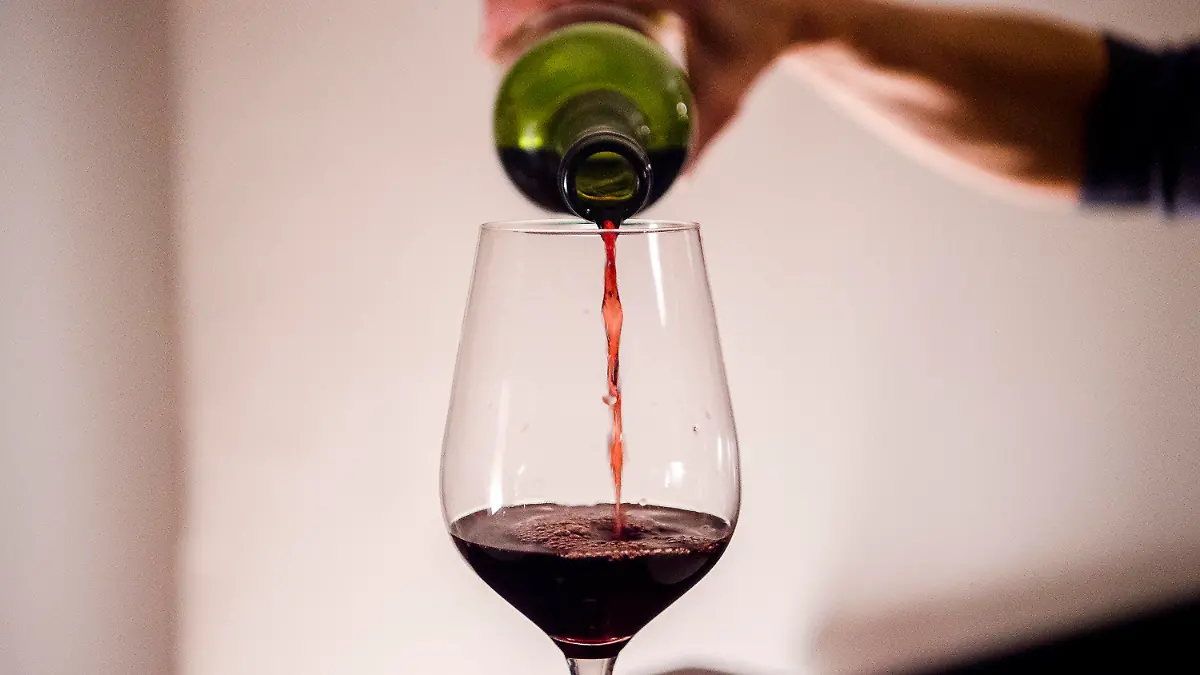 ARCHIV - 03.10.2021, Bayern, München: Eine Frau gießt zuhause Wein in ein Glas. Weniger Partys, kaum noch Weihnachtsfeiern und zwei Jahre kein Oktoberfest: Das hat sich deutlich auf das Trinkverhalten in Deutschland ausgewirkt. (Zu dpa «Pandemie verlagert den Alkoholkonsum von Partys auf die Couch») Foto: Finn Winkler/dpa +++ dpa-Bildfunk +++