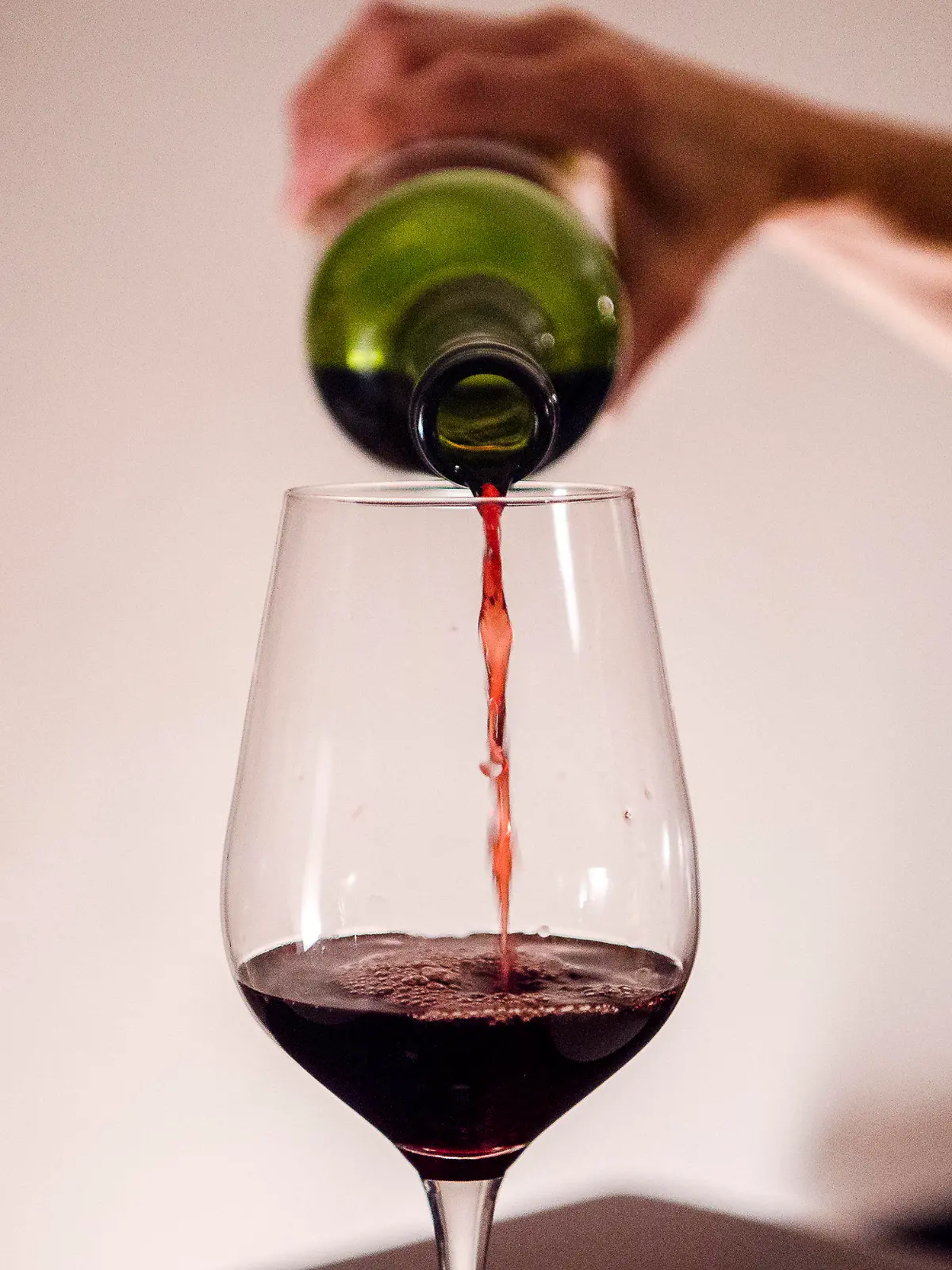 ARCHIV - 03.10.2021, Bayern, München: Eine Frau gießt zuhause Wein in ein Glas. Weniger Partys, kaum noch Weihnachtsfeiern und zwei Jahre kein Oktoberfest: Das hat sich deutlich auf das Trinkverhalten in Deutschland ausgewirkt. (Zu dpa «Pandemie verlagert den Alkoholkonsum von Partys auf die Couch») Foto: Finn Winkler/dpa +++ dpa-Bildfunk +++