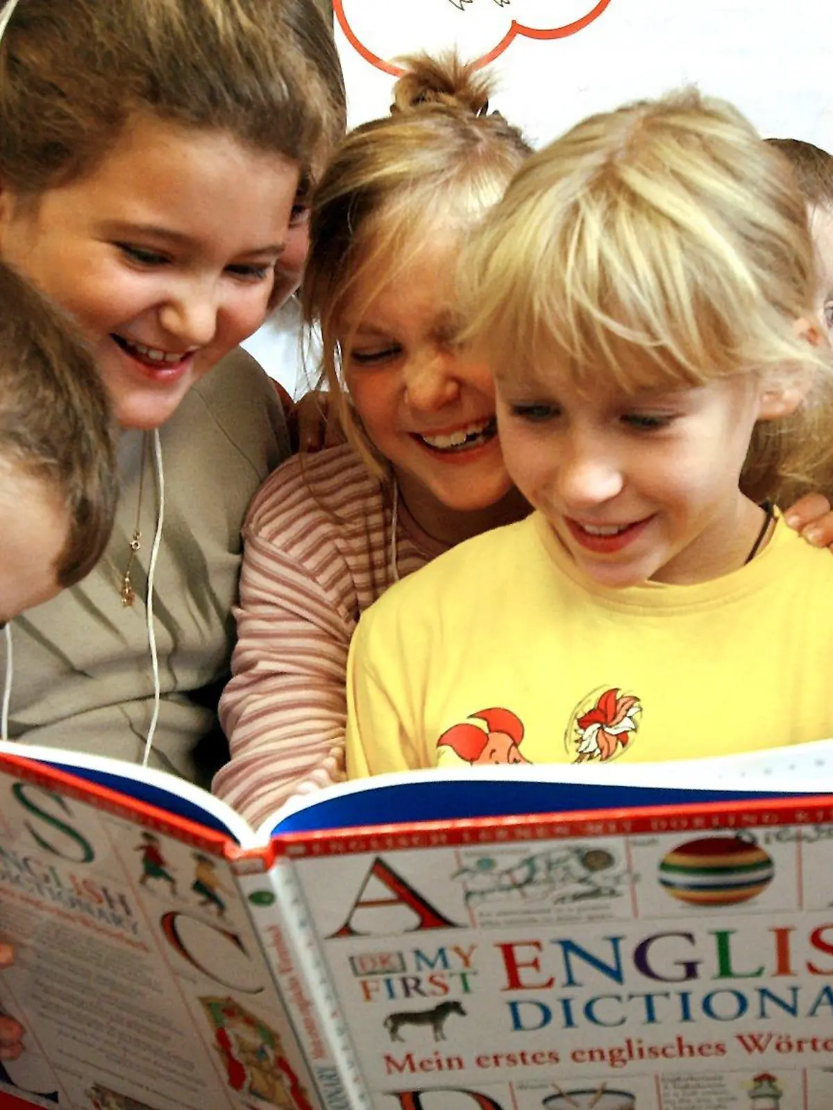 Einige Mädchen und Jungen lesen am 17.9.2003 im Englischunterricht der Klasse 3 der Joachim-Neander-Schule in Düsseldorf in einem englisch- deutschen Wörterbuch. In Nordrhein-Westfalen wird ab diesem Schuljahr in allen dritten Klassen der knapp 3500 Grundschulen Englisch unterrichtet. Dafür seien rund 4400 Lehrer durch Sprach- und Didaktikkurse qualifiziert worden. Das Land habe für die Sprachzertifikate insgesamt 3,6 Millionen Euro Zuschuss gezahlt, sagte die Referatsleiterin des Schulministeriums, Schneider. In der Grundschule soll neben dem Sprechen aber vor allem das Hörverständnis und das Erkennen von Zusammenhängen geschult werden. Auf spielerische Weise lernen die Kinder, Farben Gegenständen zuzuordnen und bekannte englische Wörter aufzusagen.