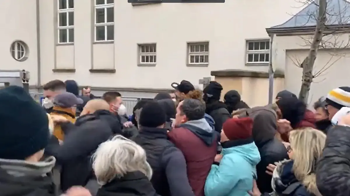 Querdenker stürmen aufs Geländer der Uniklinik.