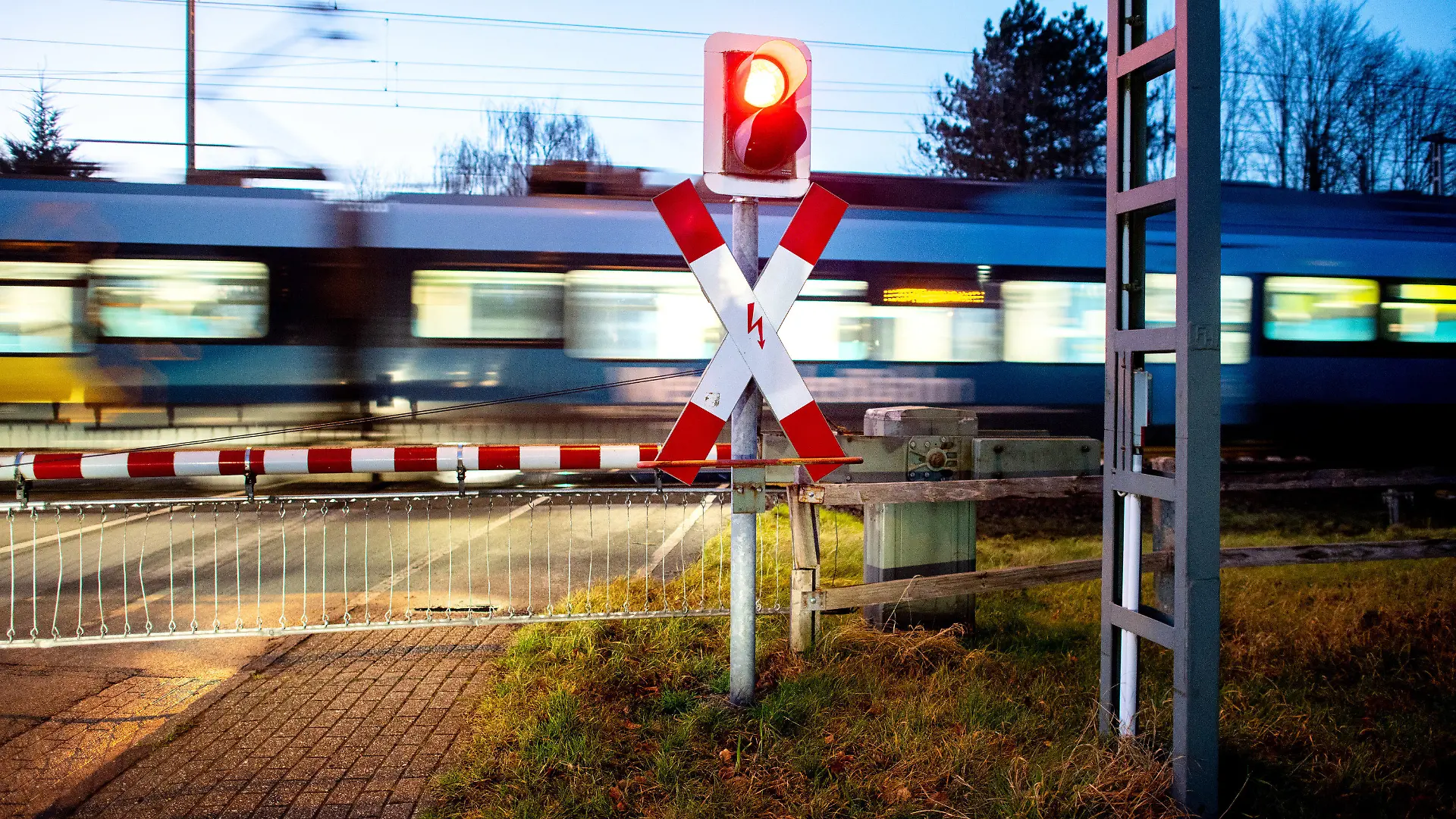 15.12.2021, Niedersachsen, Ihrhove: Ein Nahverkehrszug passiert einen Bahnübergang an der zweigleisigen Bahnstrecke nahe Ihrhove. Die sogenannte ·Wunderline· soll zukünftig Norddeutschland mit dem Norden der Niederlande über die Strecke von Bremen nach Groningen verbinden. Um eine schnellere, komfortablere und umweltfreundlichere Verbindung zwischen den Metropolregionen zu ermöglichen, wird die Strecke ausgebaut. Foto: Hauke-Christian Dittrich/dpa +++ dpa-Bildfunk +++