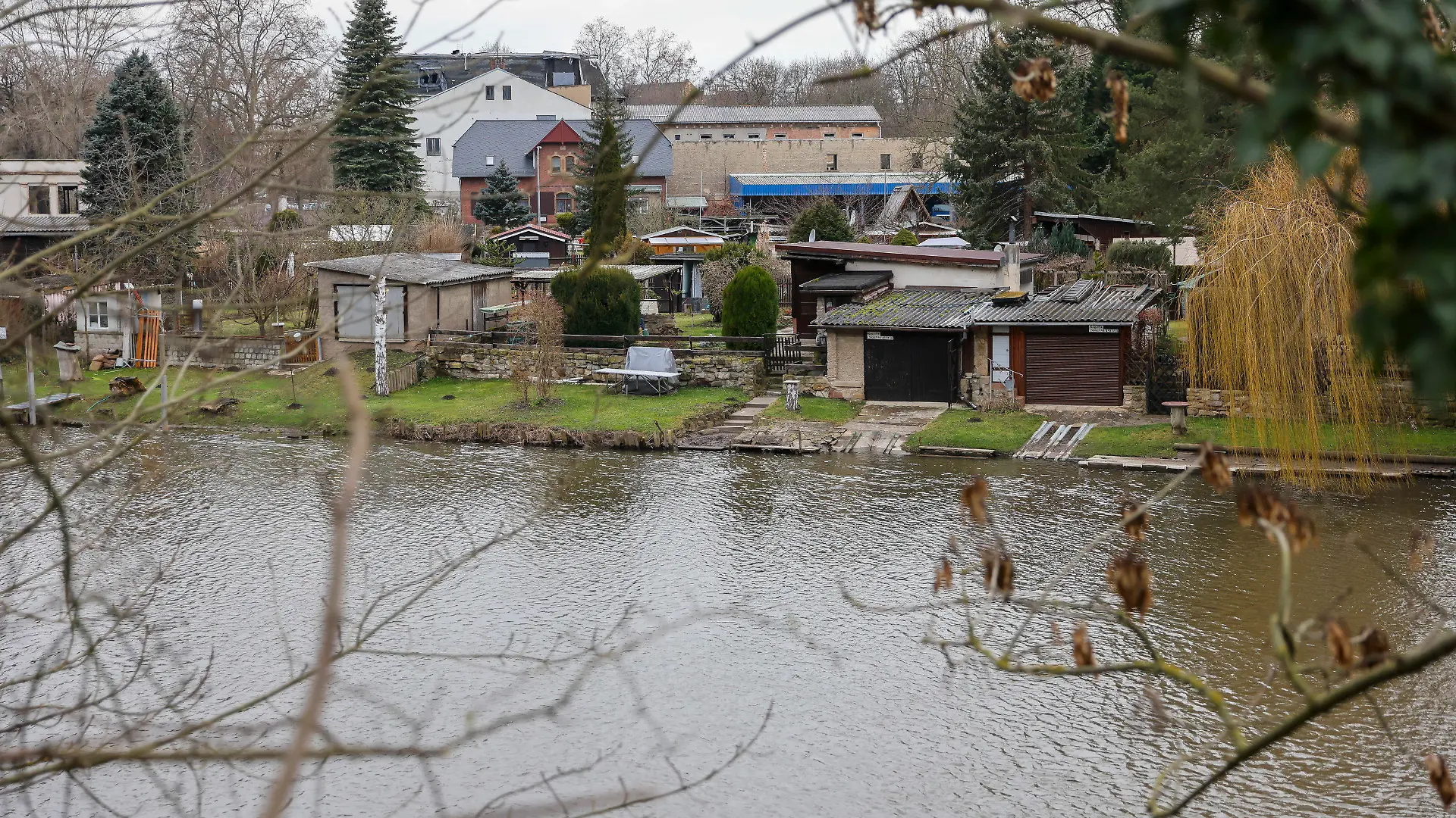 27.01.2022, Sachsen-Anhalt, Weißenfels: Eine Gartenanlage auf einer Insel in der Saale. Ein hier auf seinem Grundstück tot aufgefundener Mann ist nach Angaben der Staatsanwaltschaft vermutlich erschlagen worden. Bei der mutmaßlichen Tatwaffe handelt es sich demnach um eine Axt. Noch in der Nacht nahm die Polizei nach eigenen Angaben einen 23-jährigen Tatverdächtigen vorläufig fest. Der 53-Jährige war am Mittwochabend von seiner Lebensgefährtin auf dem eigenen Gartengrundstück in Bahnhofsnähe gefunden worden. Foto: Jan Woitas/dpa-Zentralbild/dpa +++ dpa-Bildfunk +++