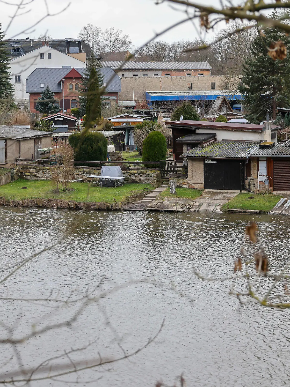 27.01.2022, Sachsen-Anhalt, Weißenfels: Eine Gartenanlage auf einer Insel in der Saale. Ein hier auf seinem Grundstück tot aufgefundener Mann ist nach Angaben der Staatsanwaltschaft vermutlich erschlagen worden. Bei der mutmaßlichen Tatwaffe handelt es sich demnach um eine Axt. Noch in der Nacht nahm die Polizei nach eigenen Angaben einen 23-jährigen Tatverdächtigen vorläufig fest. Der 53-Jährige war am Mittwochabend von seiner Lebensgefährtin auf dem eigenen Gartengrundstück in Bahnhofsnähe gefunden worden. Foto: Jan Woitas/dpa-Zentralbild/dpa +++ dpa-Bildfunk +++