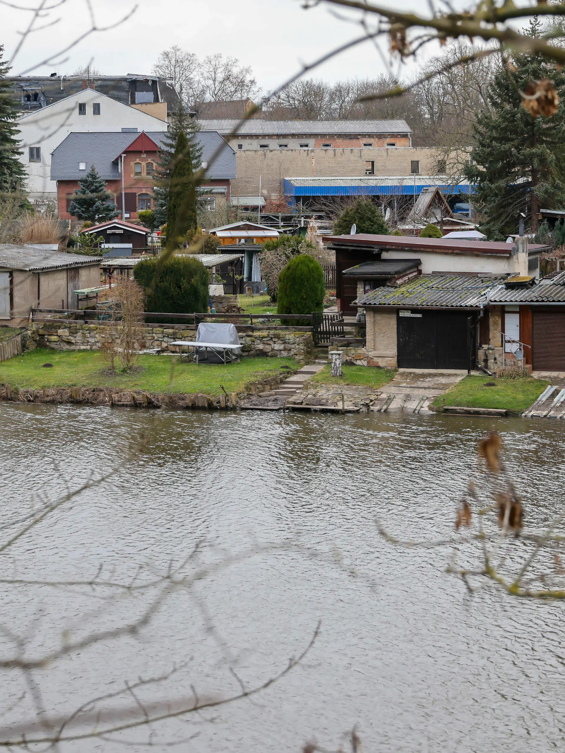 27.01.2022, Sachsen-Anhalt, Weißenfels: Eine Gartenanlage auf einer Insel in der Saale. Ein hier auf seinem Grundstück tot aufgefundener Mann ist nach Angaben der Staatsanwaltschaft vermutlich erschlagen worden. Bei der mutmaßlichen Tatwaffe handelt es sich demnach um eine Axt. Noch in der Nacht nahm die Polizei nach eigenen Angaben einen 23-jährigen Tatverdächtigen vorläufig fest. Der 53-Jährige war am Mittwochabend von seiner Lebensgefährtin auf dem eigenen Gartengrundstück in Bahnhofsnähe gefunden worden. Foto: Jan Woitas/dpa-Zentralbild/dpa +++ dpa-Bildfunk +++