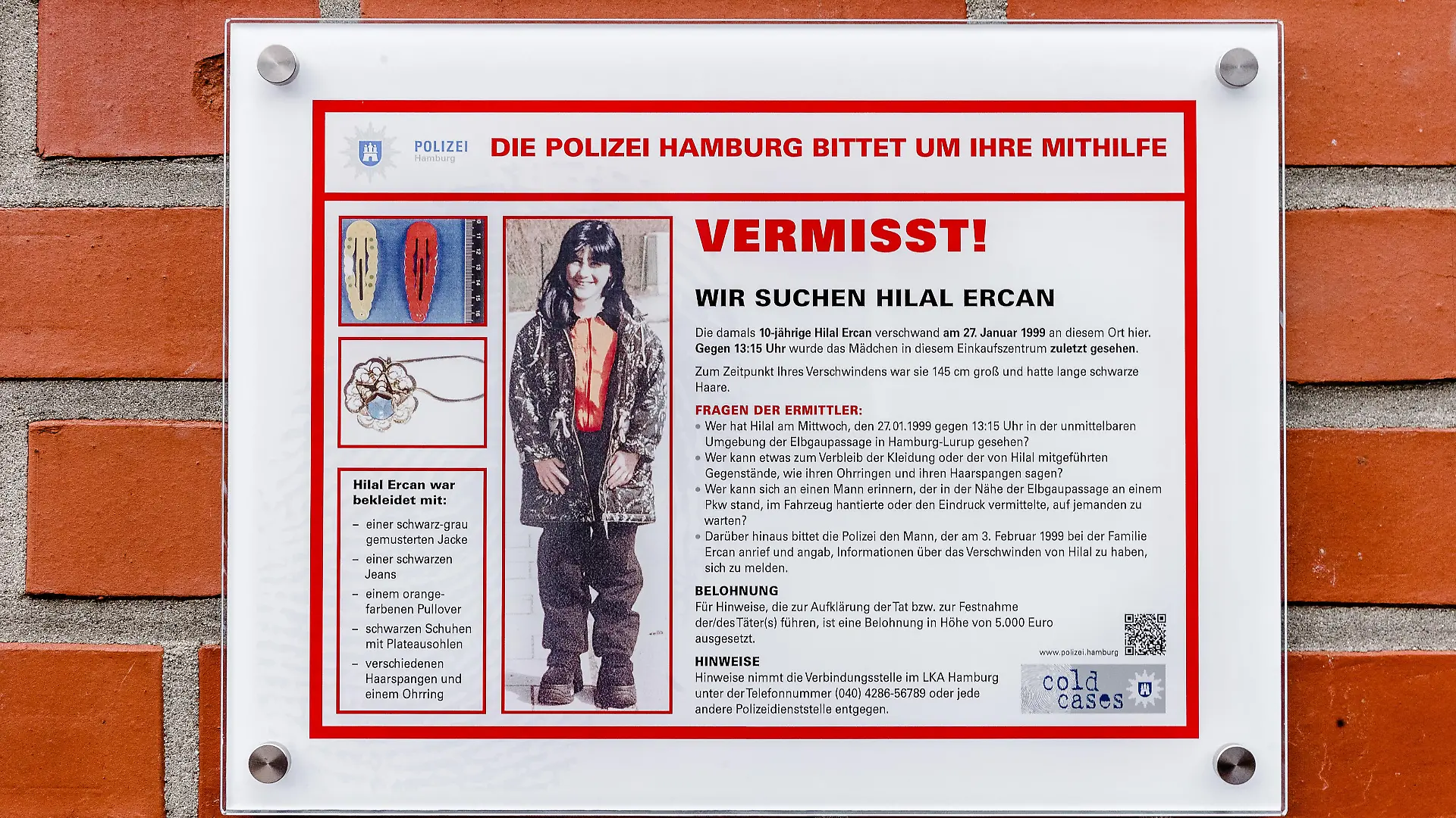 Eine Tafel der Polizei Hamburg mit Informationen, Bildern und der Überschrift "Vermisst! Wir suchen Hilal Ercan" ist am 27.01.2018 in Hamburg an einem Einkaufszentrum im Stadtteil Lurup zu sehen. Sie soll am Ort des Verschwindens der 1999 zehn Jahre alten Hilal mögliche Zeugen ermutigen, sich mit Aussagen an die Polizei zu wenden. Hilal ist das einzige langzeitvermisste Kind in Hamburg. ACHTUNG: Verwendung nur im Rahmen der Berichtersttatung über die öffentliche Fahndung, so lange wie diese läuft. Foto: Markus Scholz/dpa | Verwendung weltweit