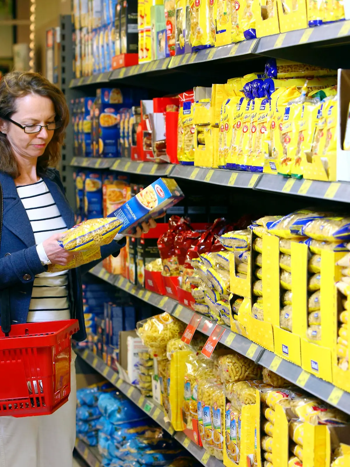 Frau kauft Nudeln, Pasta ein, Selbstbedienung, Lebensmittelabteilung, Supermarkt, Deutschland, Europa || Modellfreigabe vorhanden